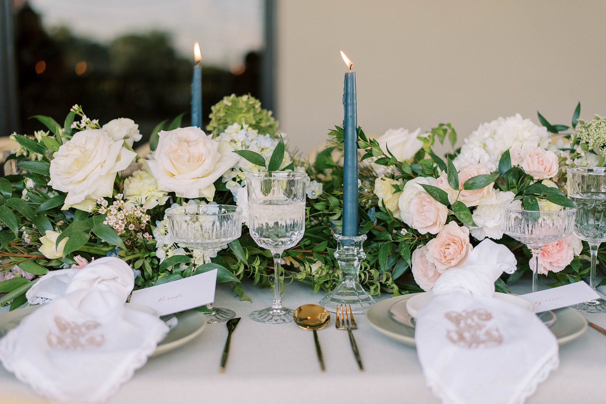 greenery table runner with blue taper candles and blush accents