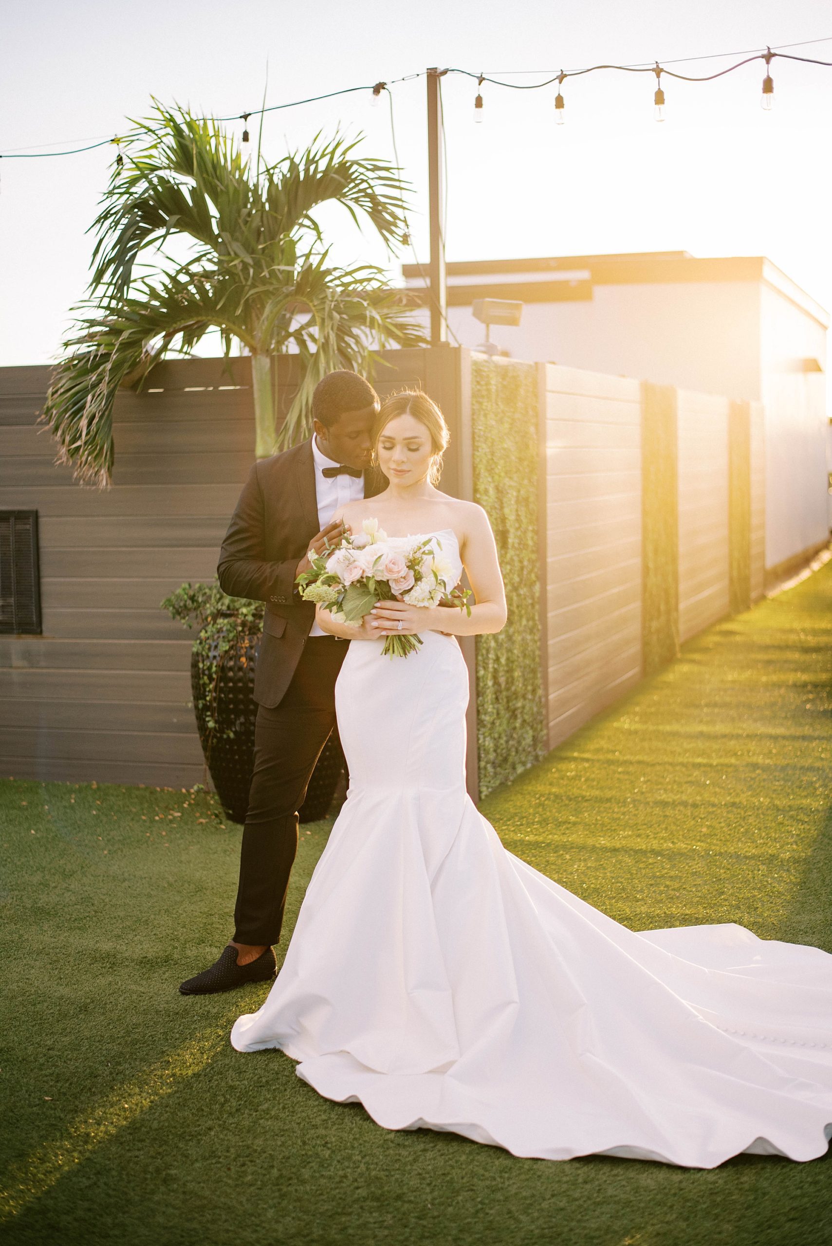 bride and groom hug at sunset along St. Pete Beach