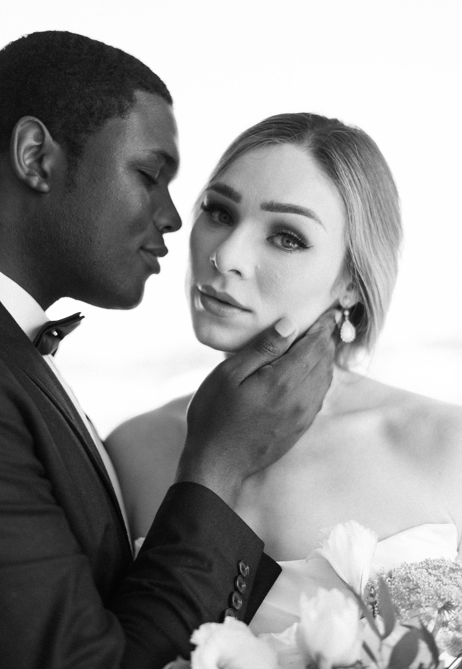 groom holds bride's cheek