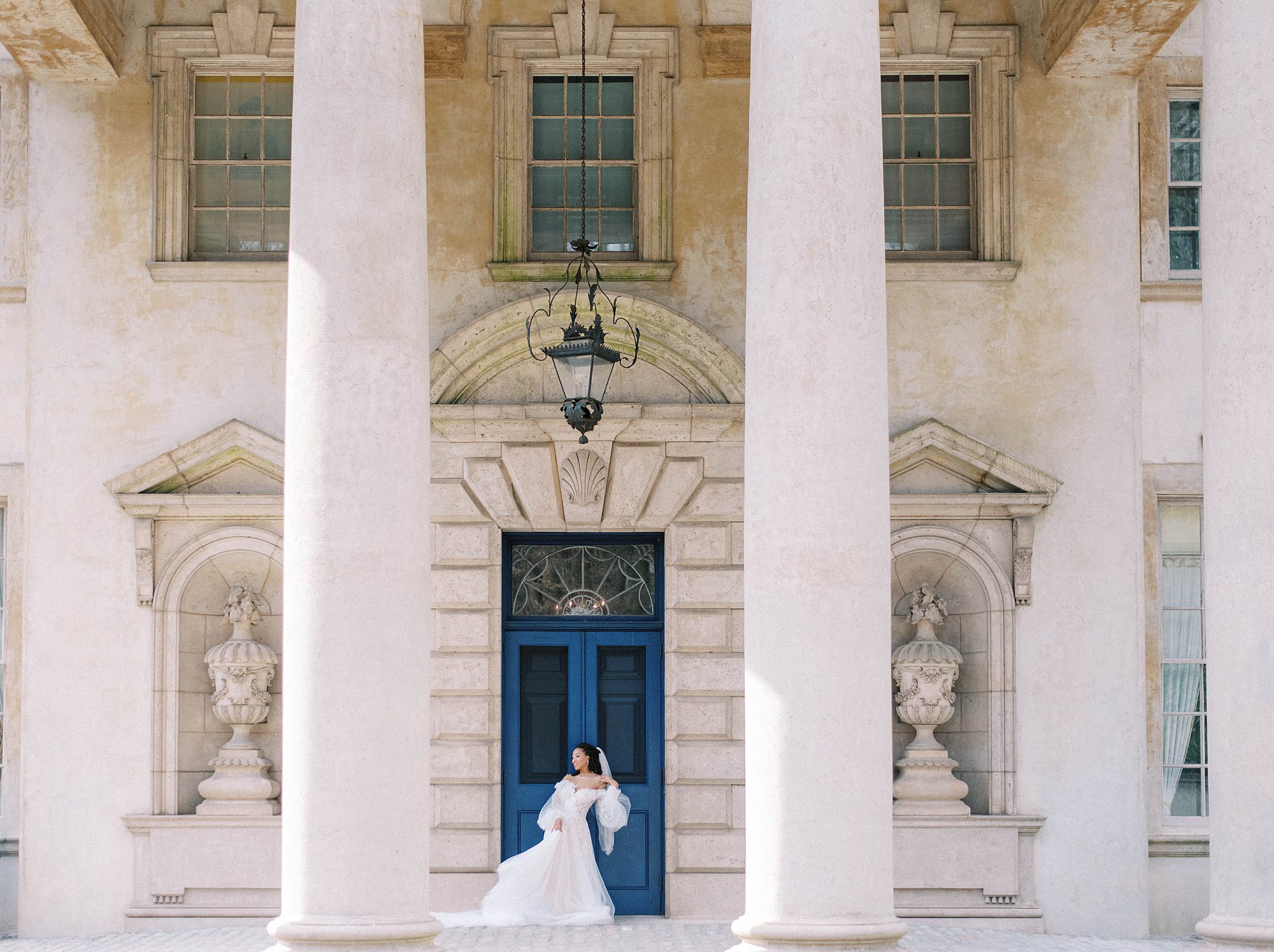 bride poses by blue door at Swan House Atlanta manor home