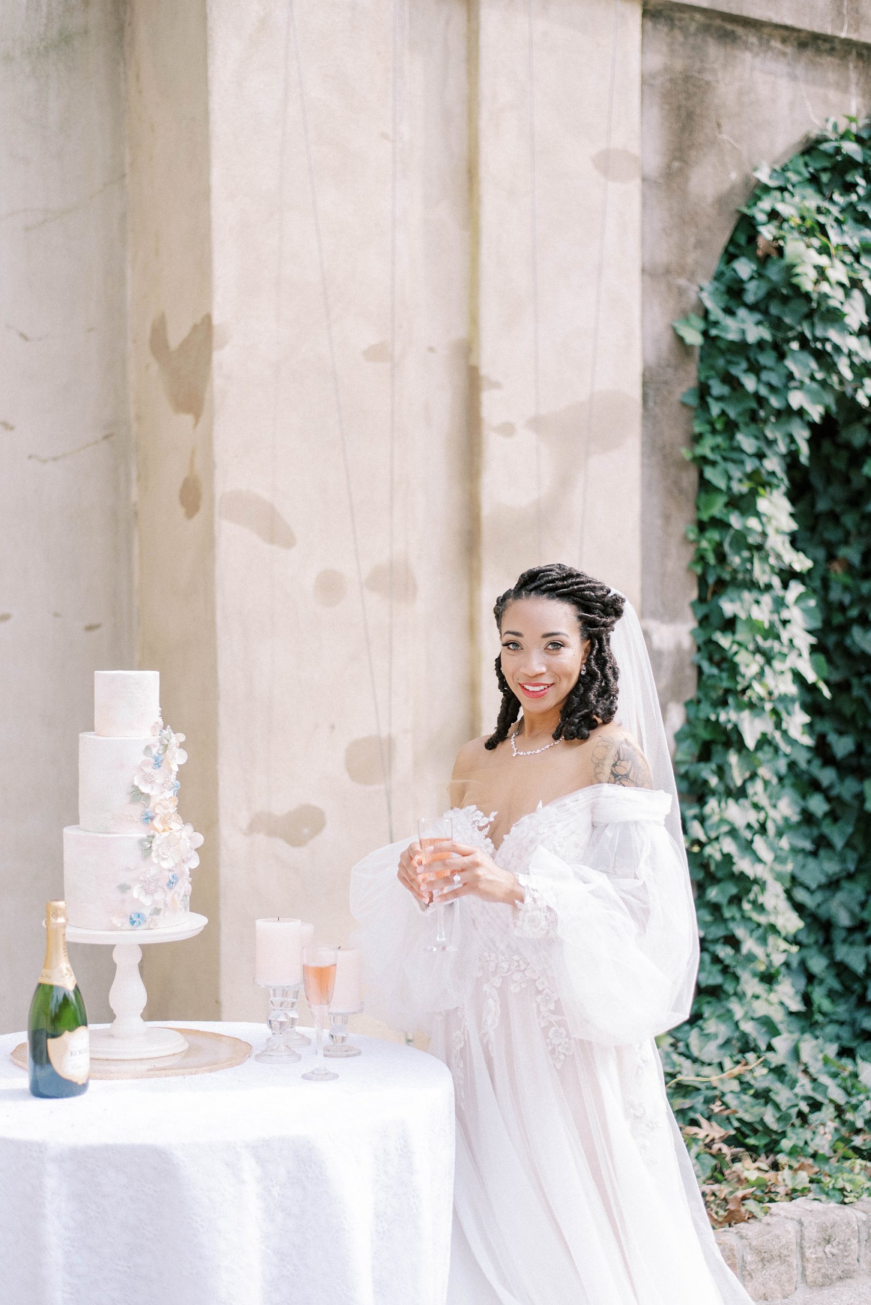 bride poses by tiered wedding cake at Swan House