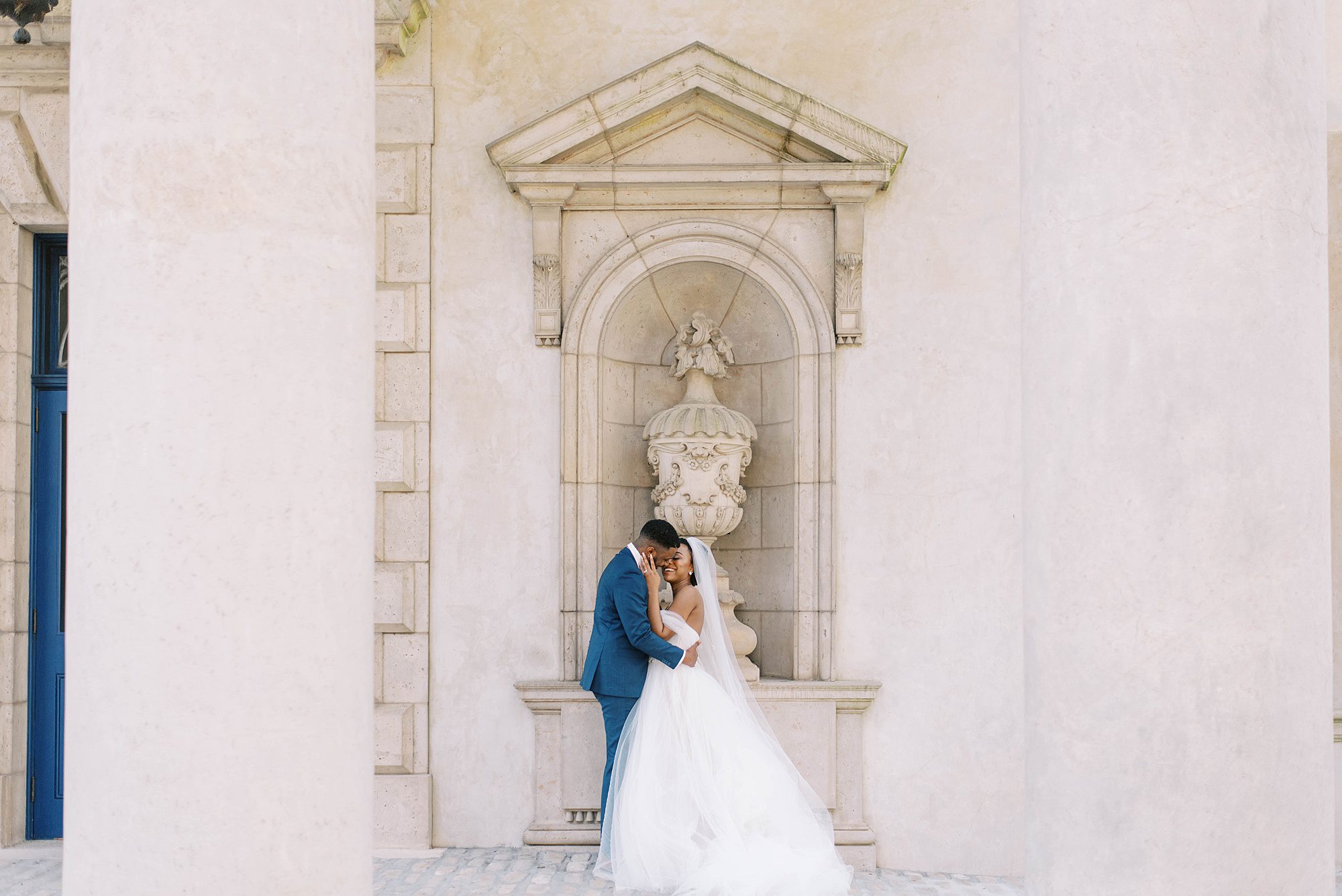 bride and groom pose by manor home during Swan House Atlanta wedding