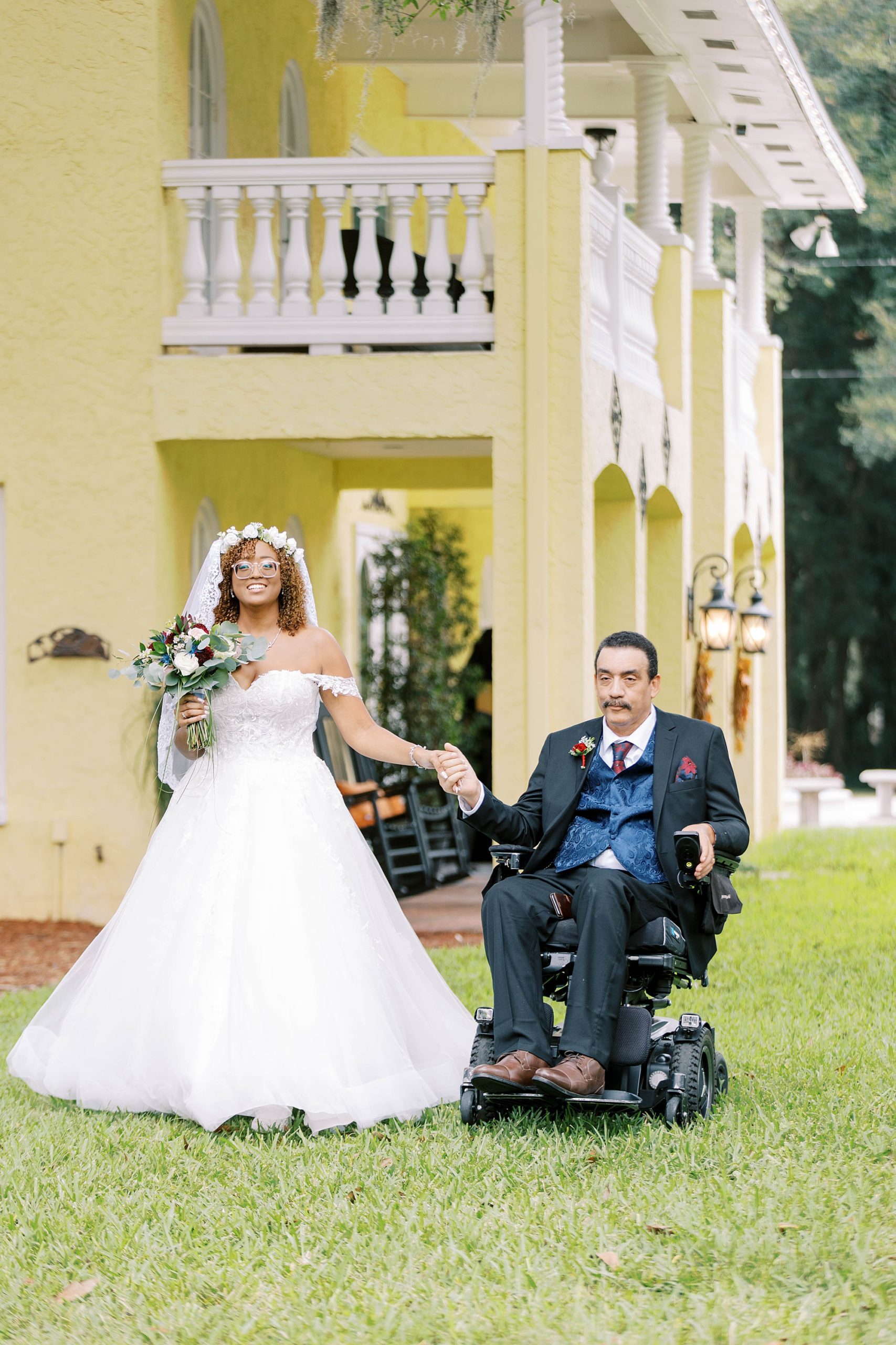 bride walks down aisle holding hands with father in wheelchair