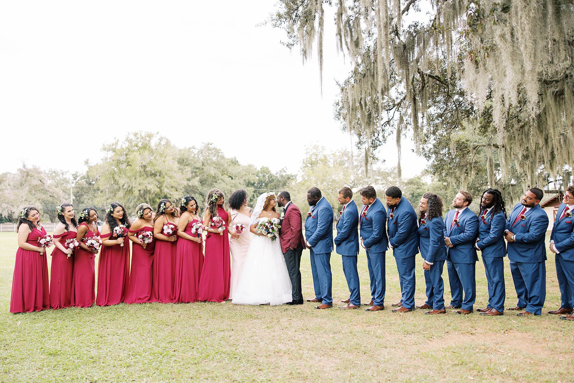 bride and groom kiss while bridal party surrounds them