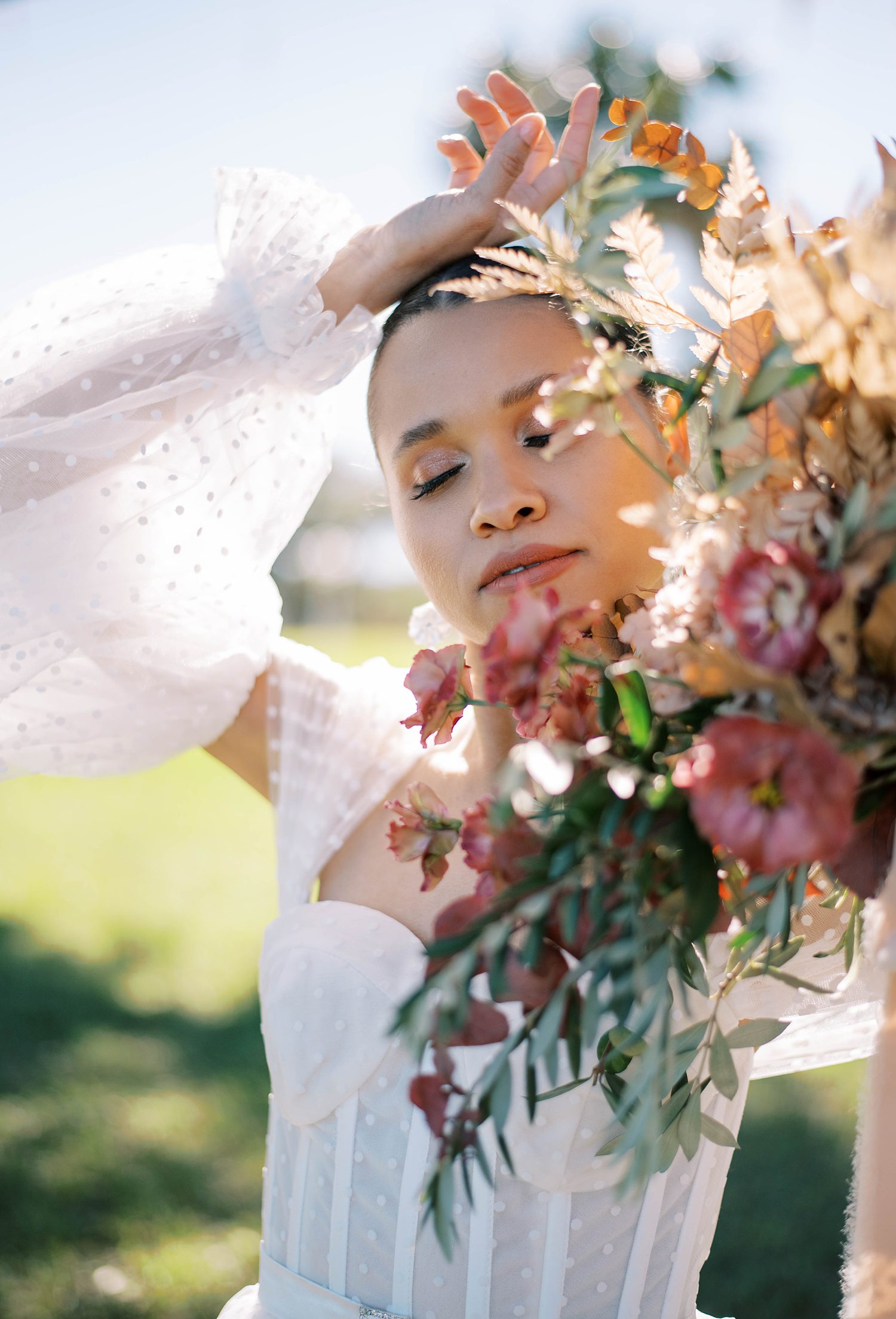 bride holds bouquet of wildflowers with muted colors