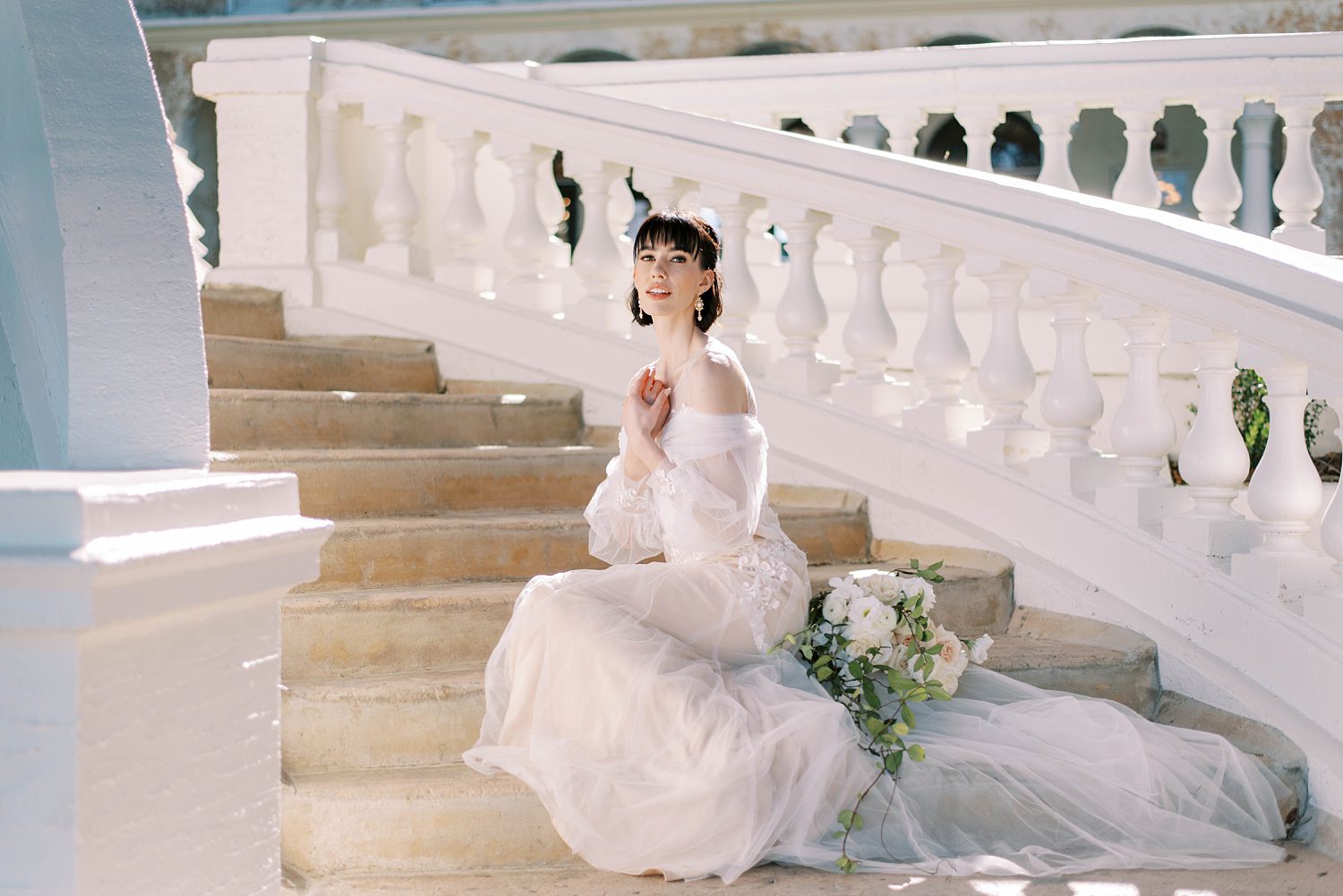 bride sits on steps at BellaCosa Lakeside
