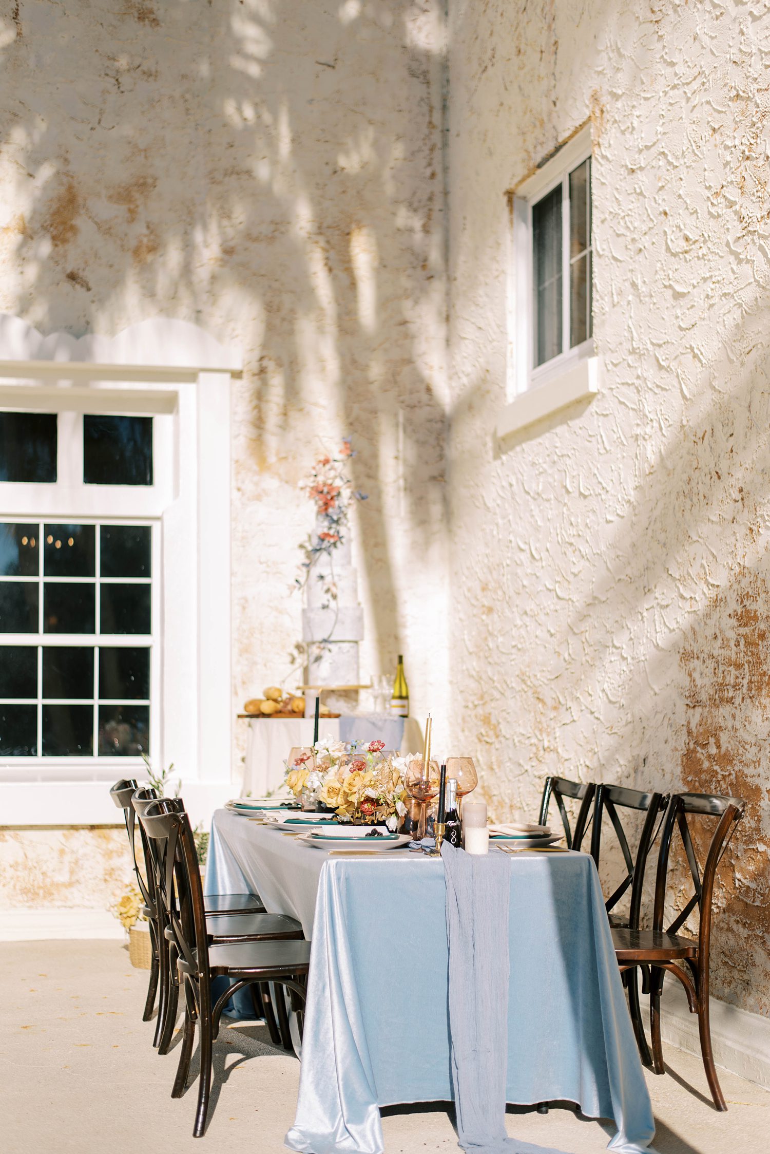 intimate outdoor wedding reception with blue table cloth on wooden table