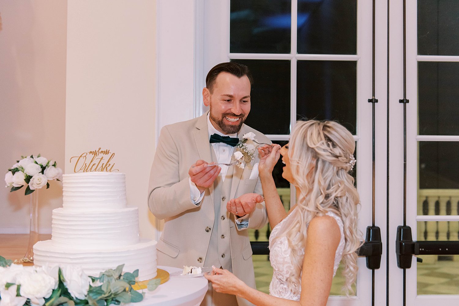 groom feeds bride cake during wedding reception in Florida