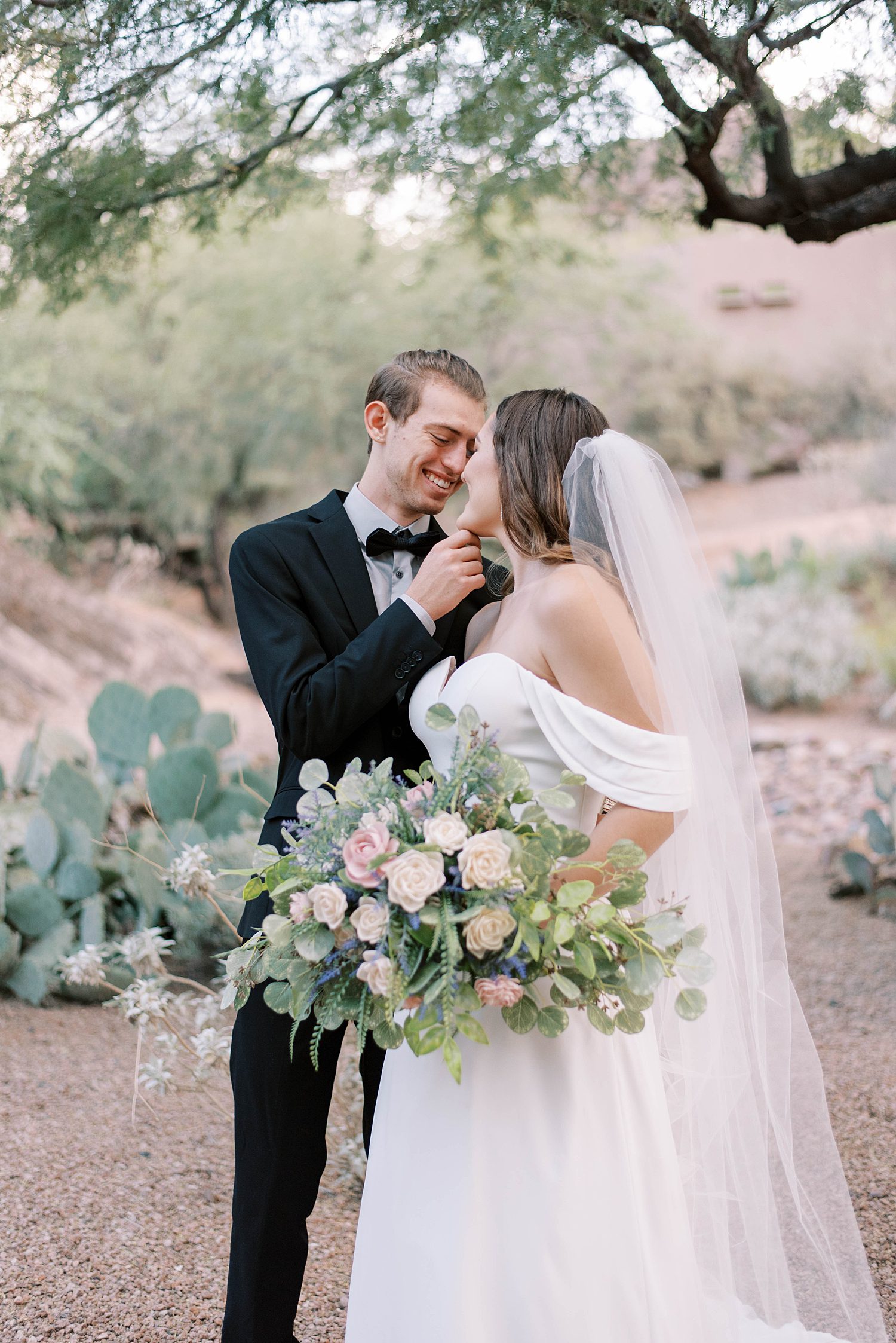 groom holds bride's chin during portraits at Buttes Marriott Hotel