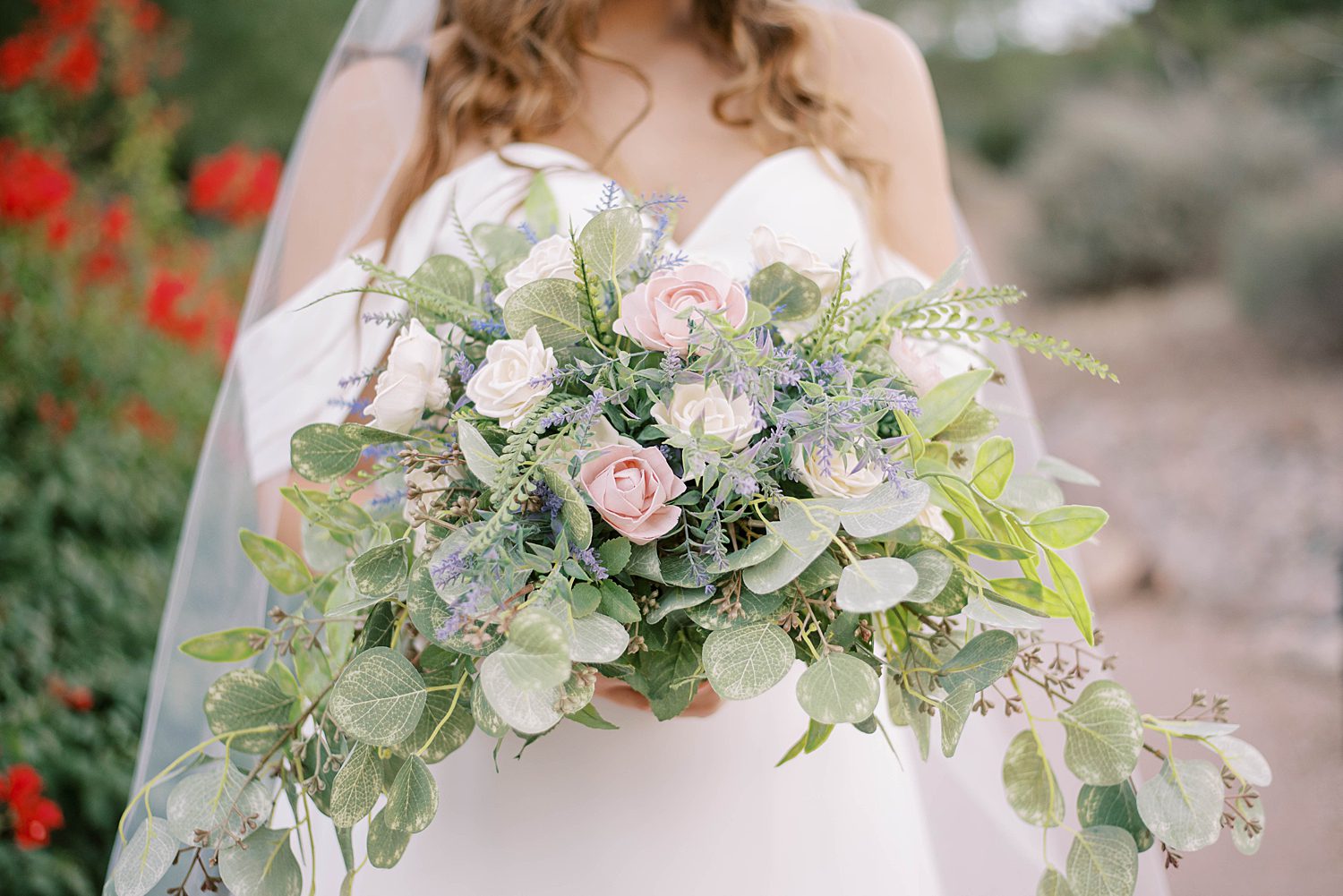 bride holds bouquet of pink roses