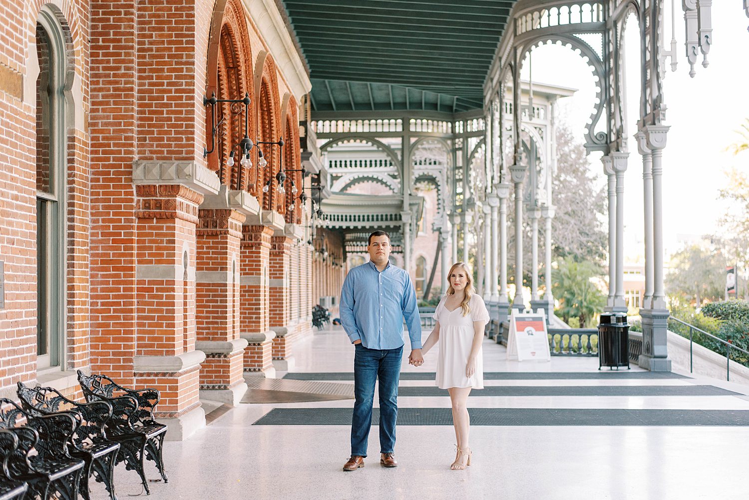 couple holds hands under awning at the University of Tampa