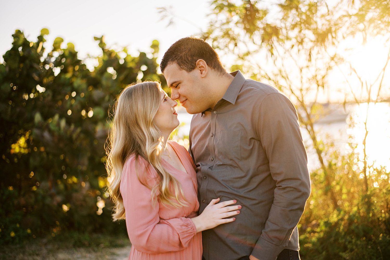 couple stands with noses touching at sunset on Davis Island