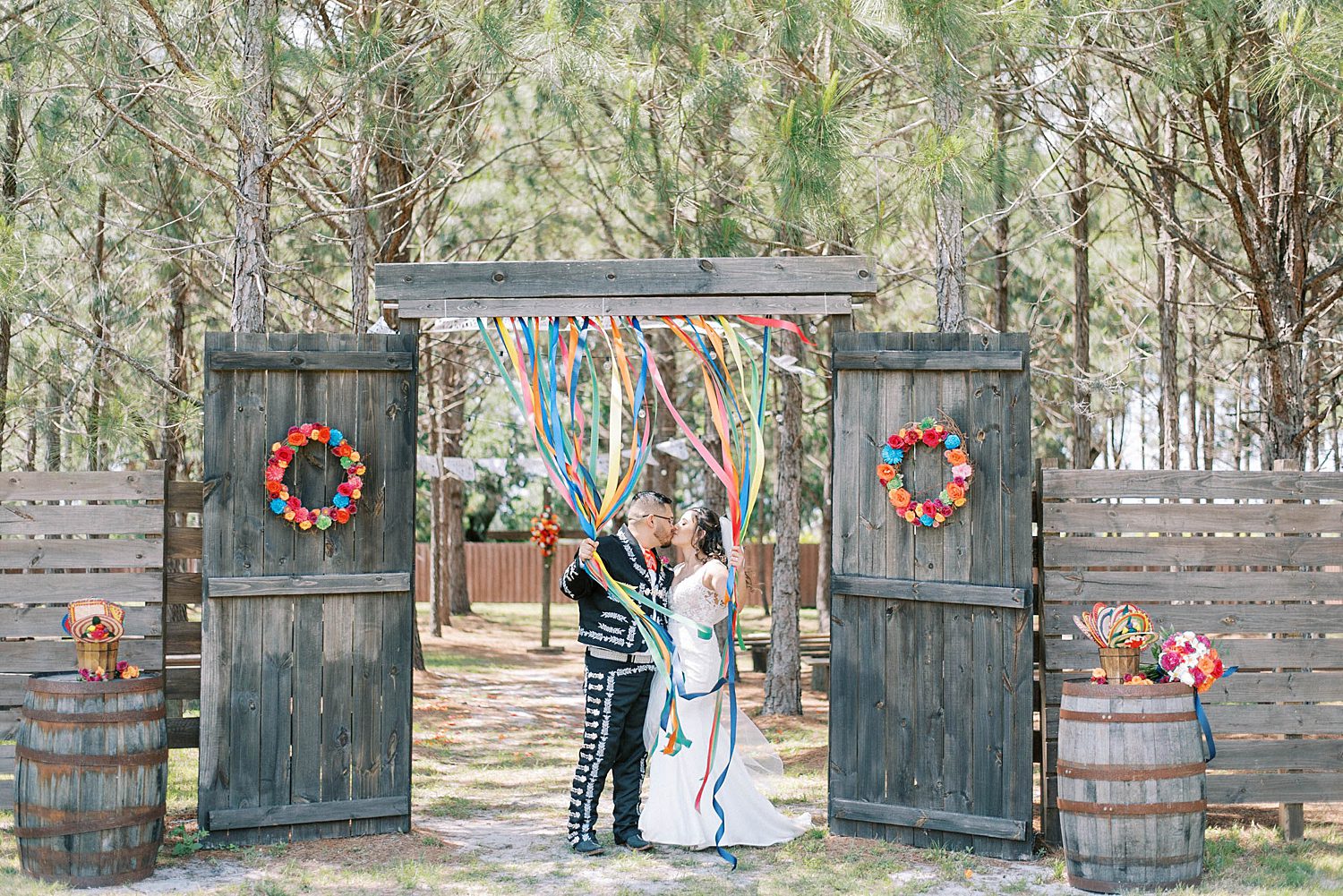 newlyweds kiss holding onto colorful banners