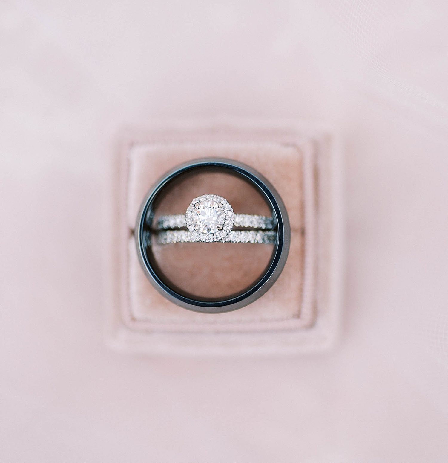 wedding rings sit in pastel pink box