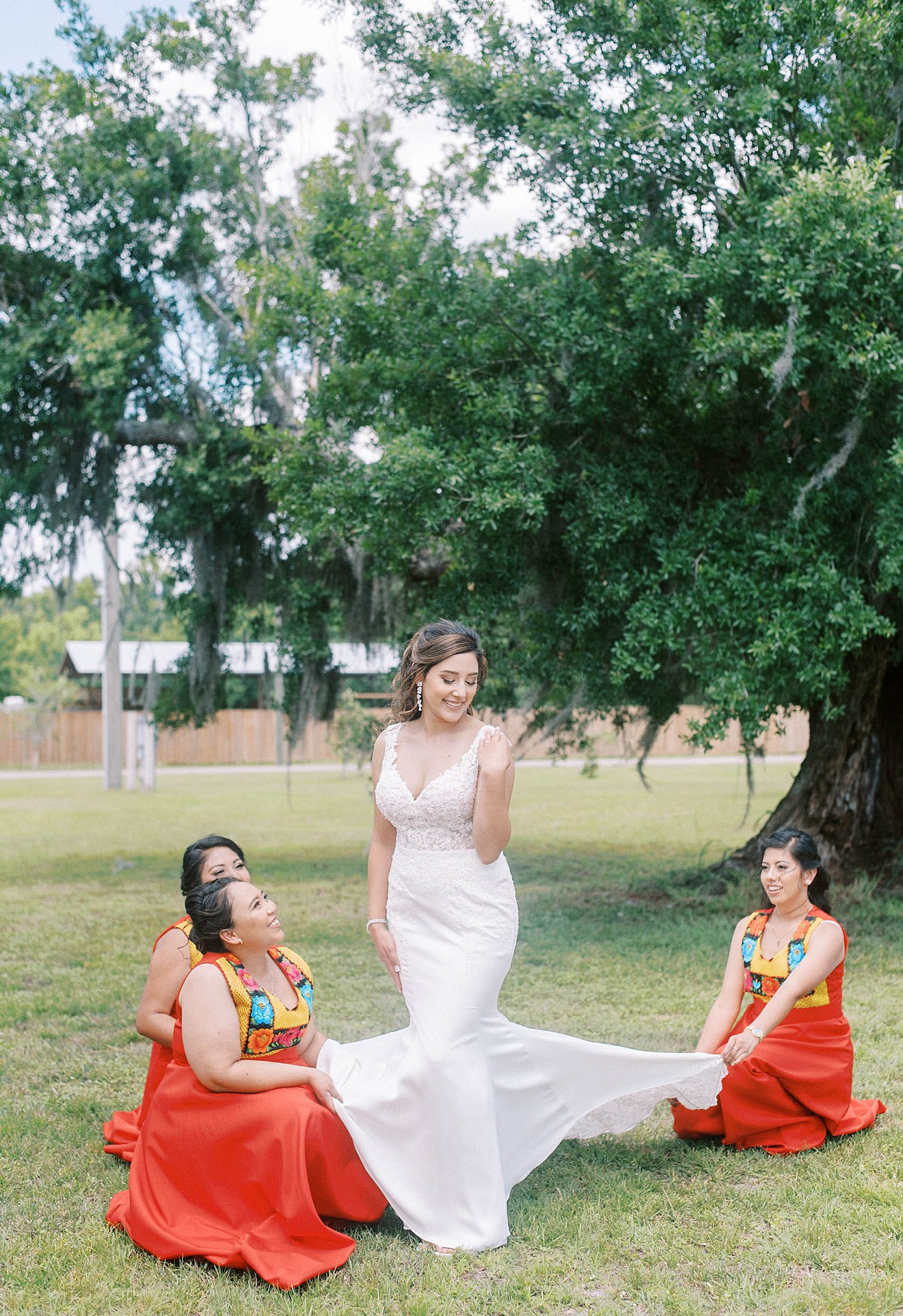bridesmaids help bride with wedding dress