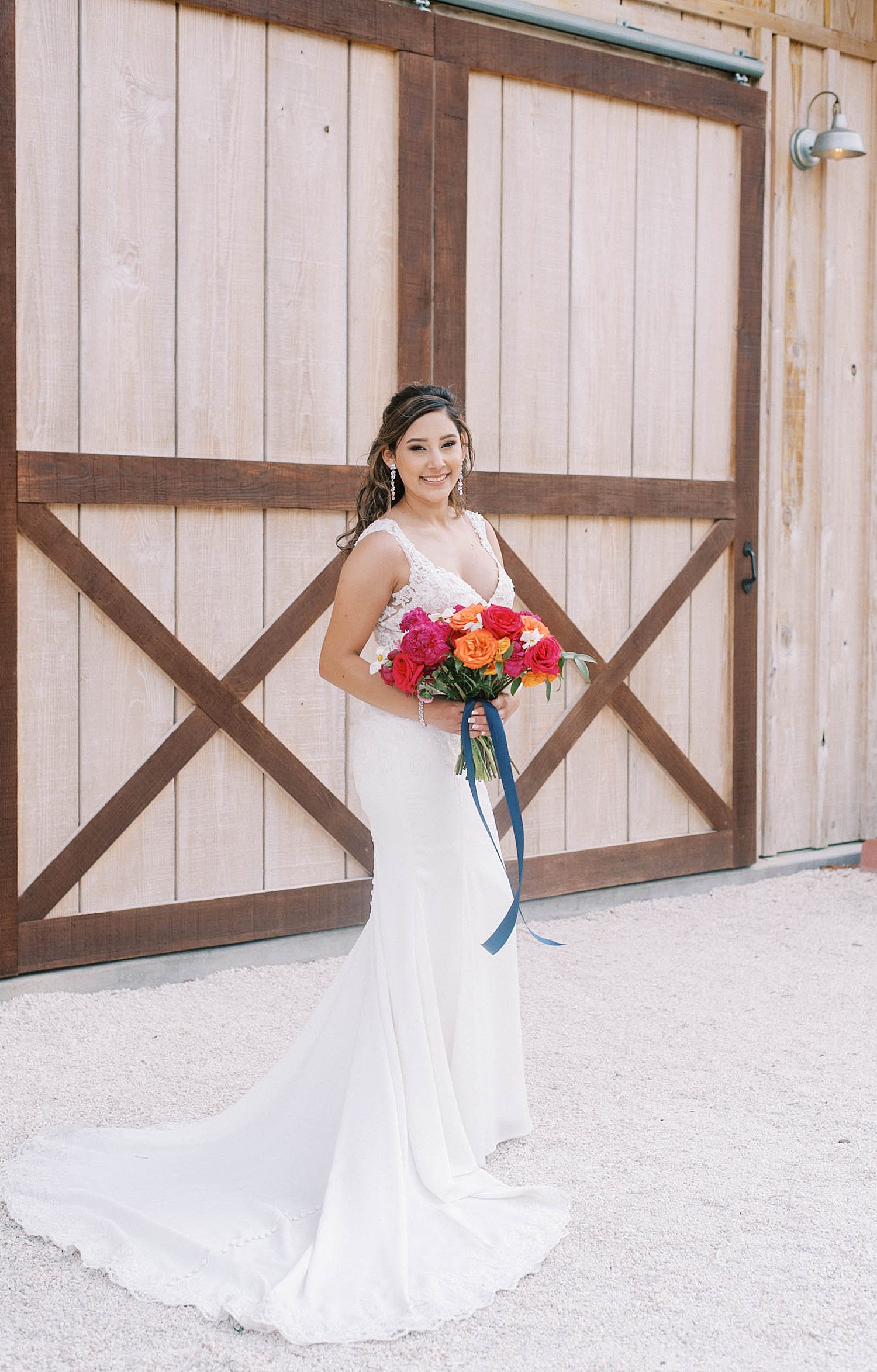 bride holds bouquet of bright flowers for Mexican inspired wedding