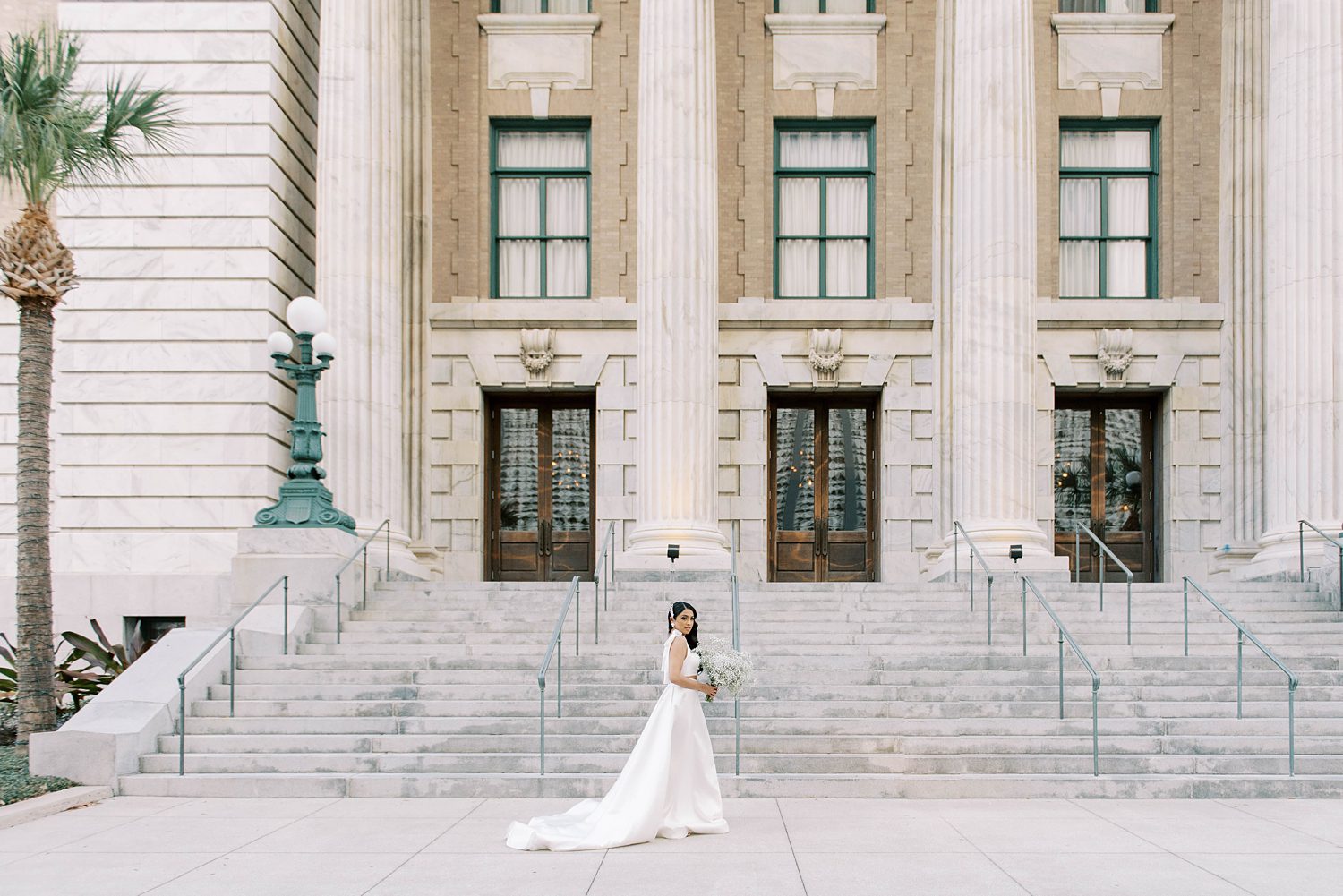 bride poses in Delana Muse gown outside Tampa courthouse