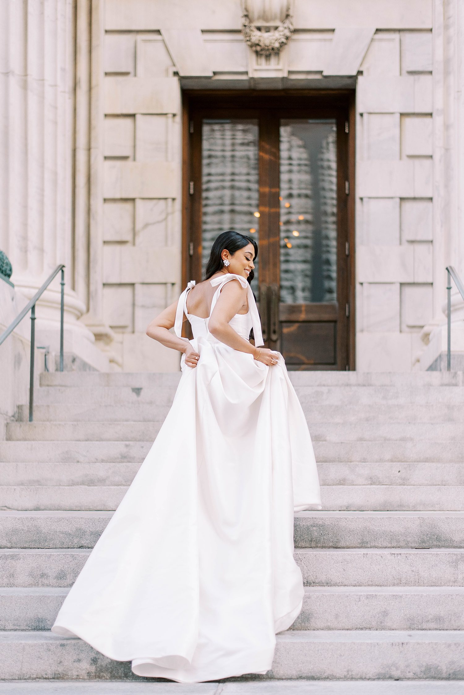 bride walks up steps of Tampa courthouse in modern two piece Delana Muse gown