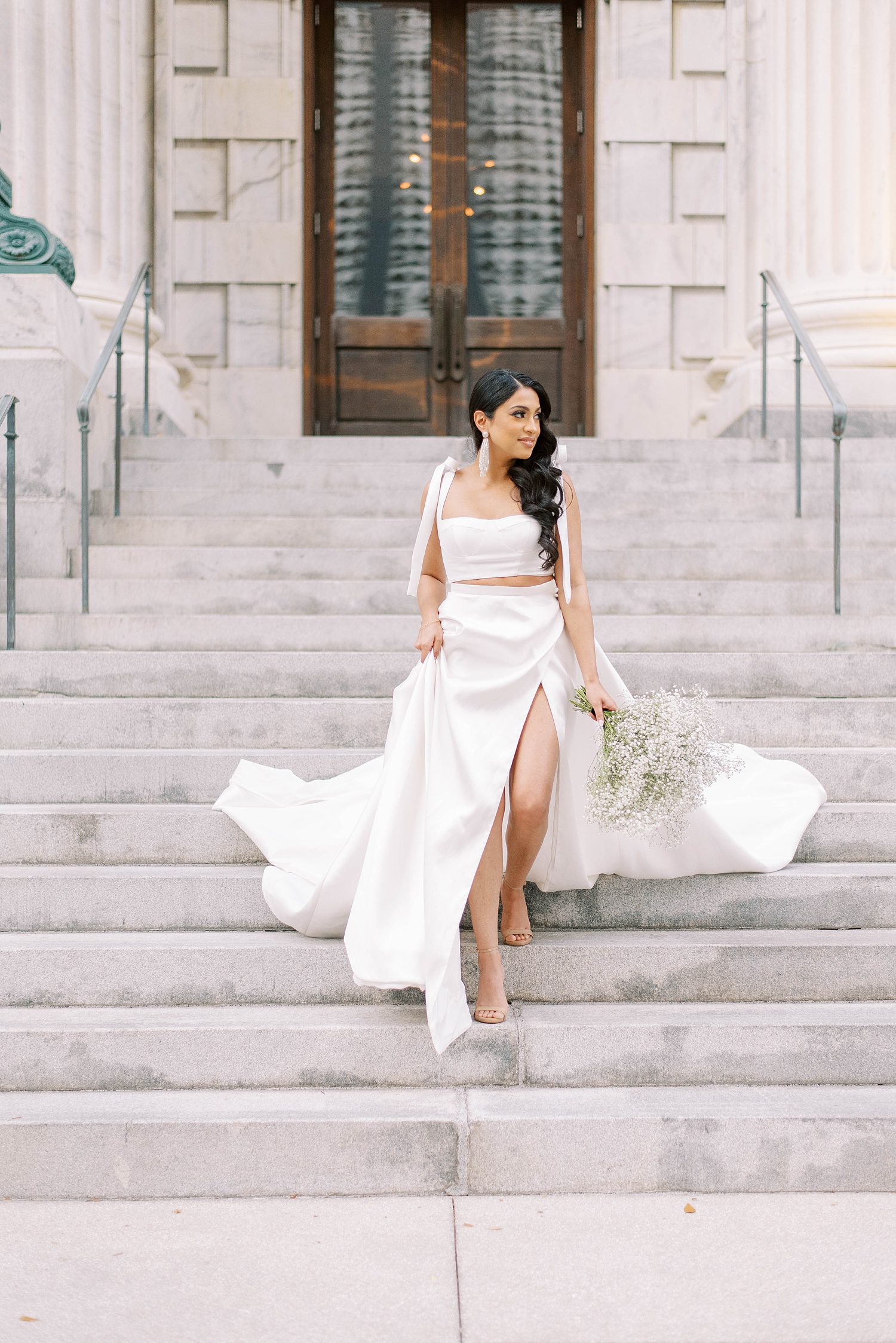 woman walks down steps in modern Delana Muse gown