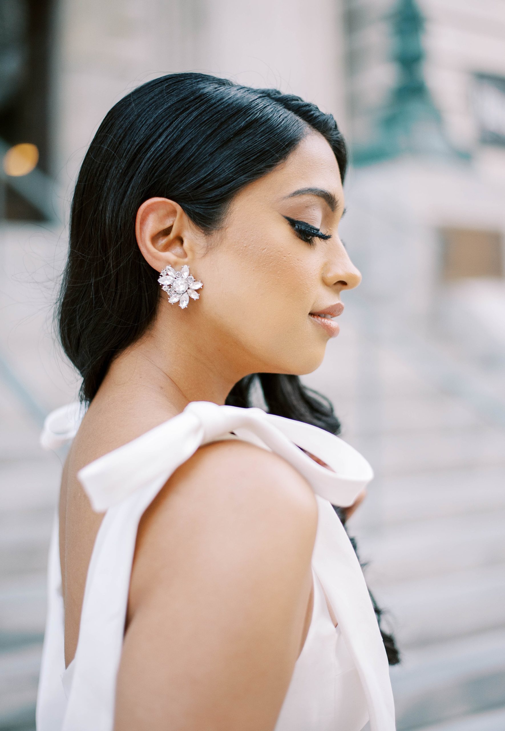 woman looks down showing off earrings 