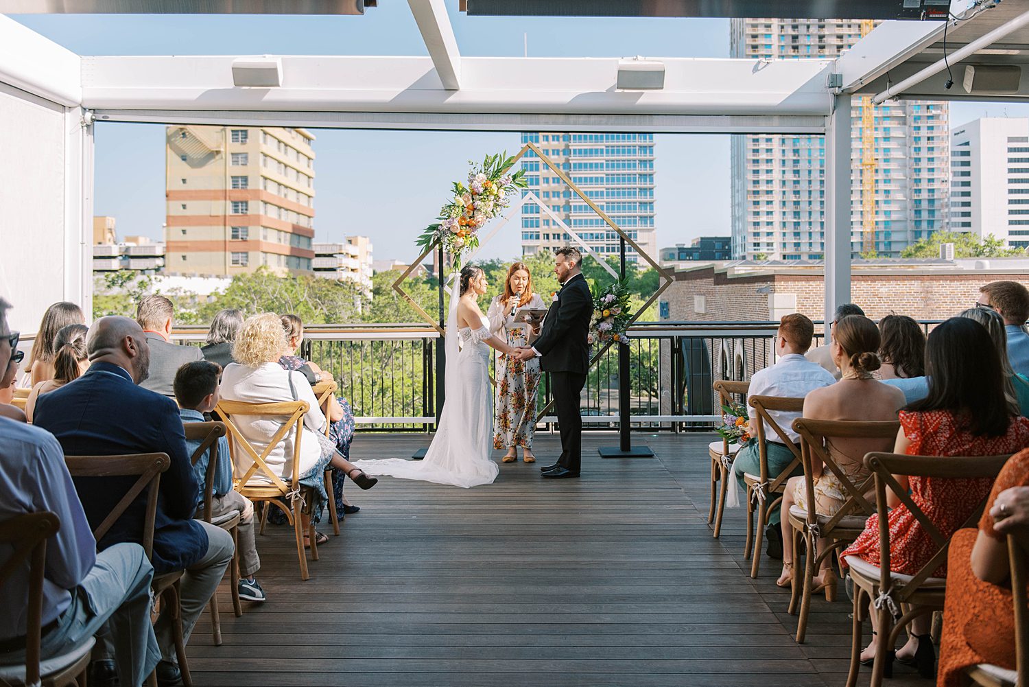 bride and groom exchange vows in bilingual wedding ceremony on rooftop of Red Mesa Cantina