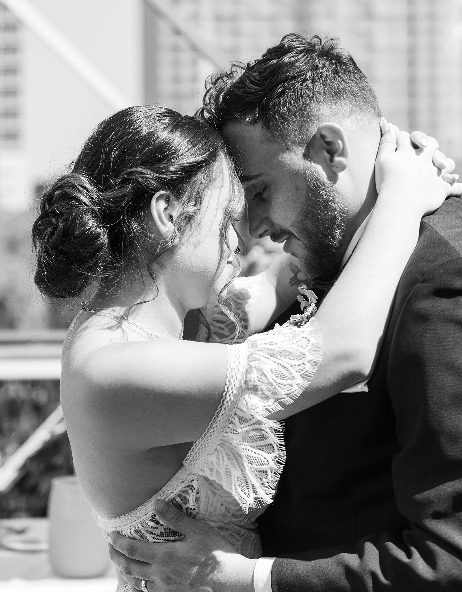 bride and groom hug with foreheads touching on rooftop at Red Mesa Cantina