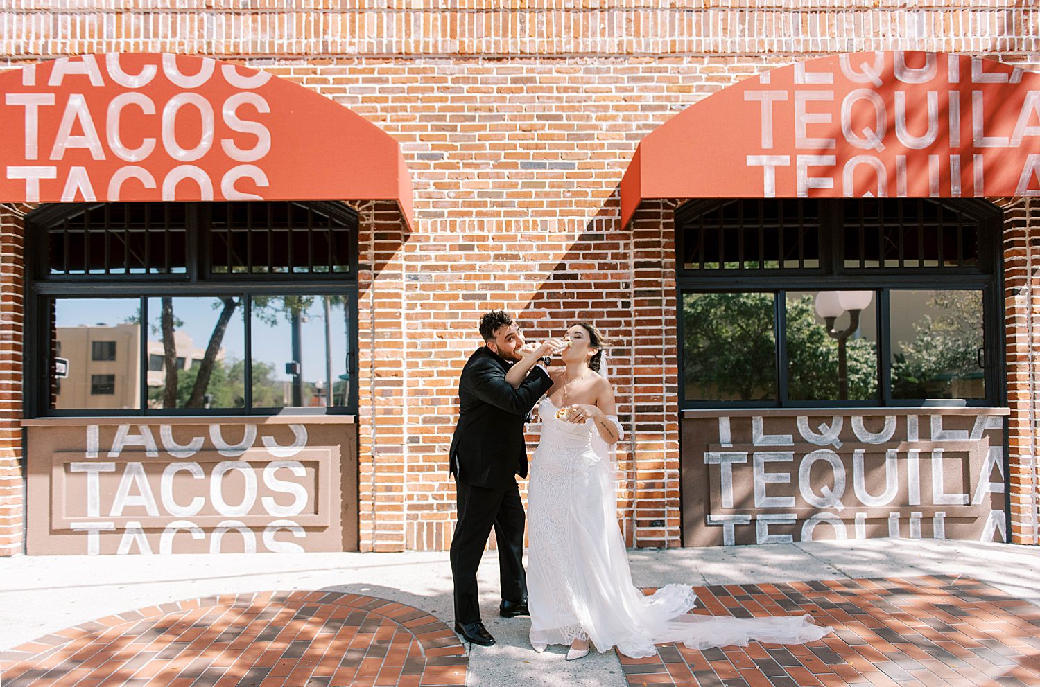 bride and groom drink tequila and eat tacos outside Red Mesa Cantina