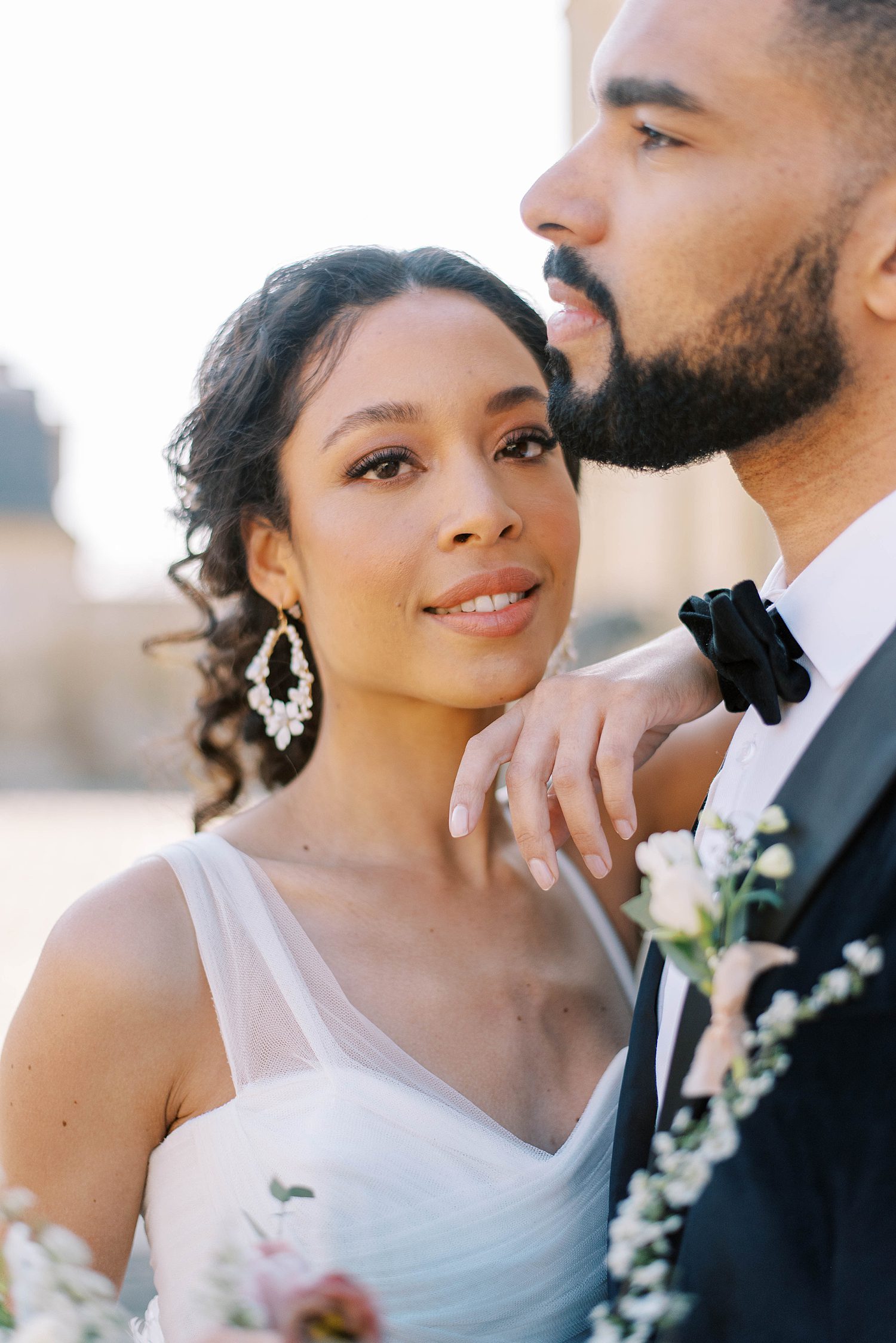 French bride leans against groom's shoulder smiling