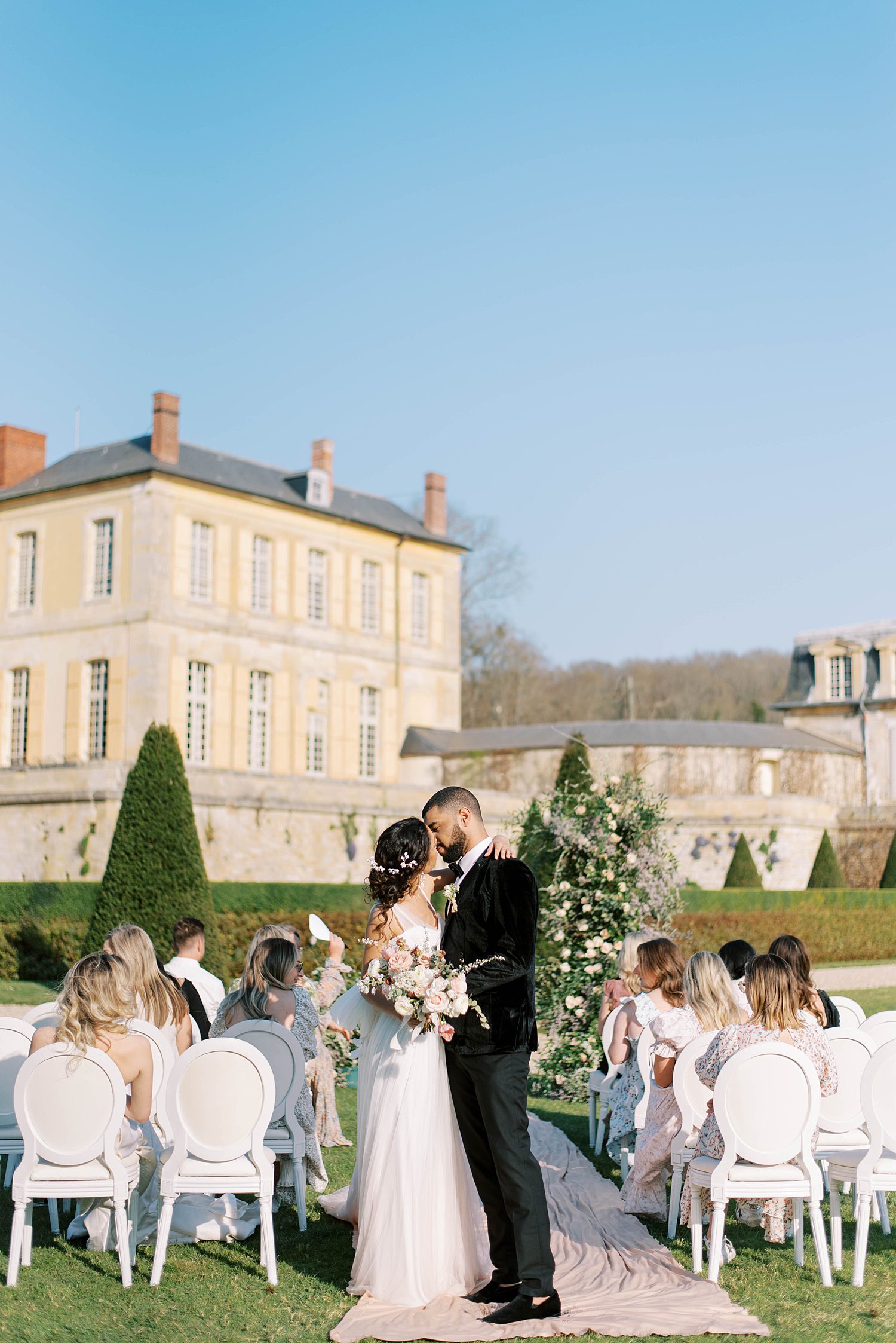 bride and groom kiss walking up aisle after Chateau de Villette wedding ceremony