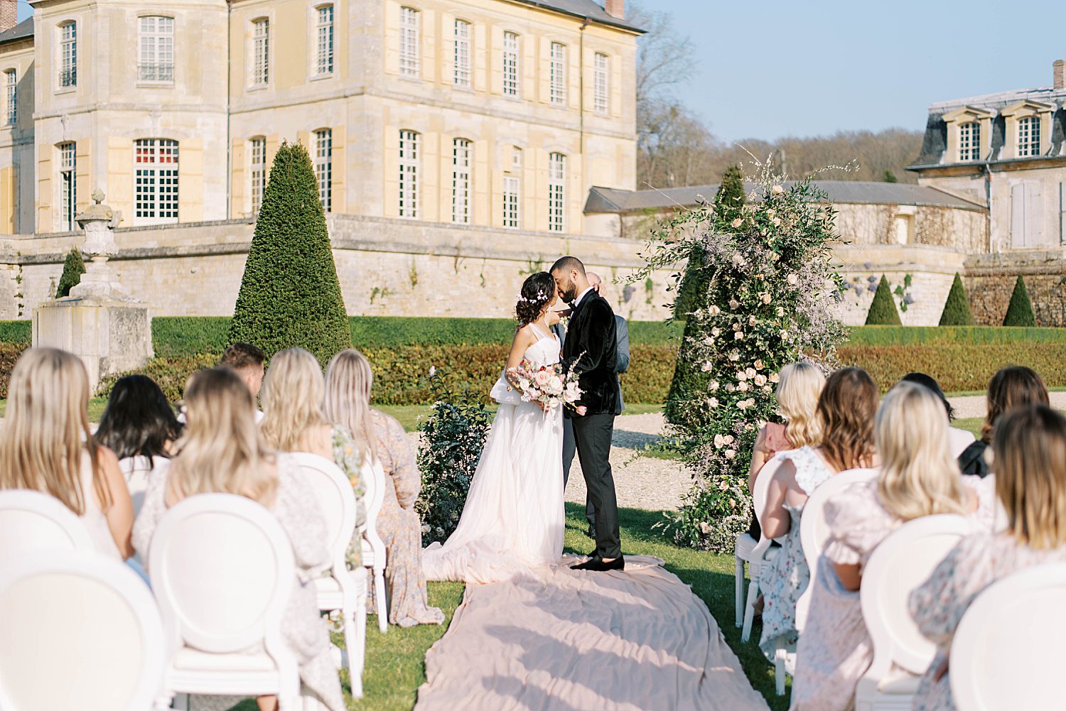 newlyweds kiss during wedding ceremony at Chateau de Villette