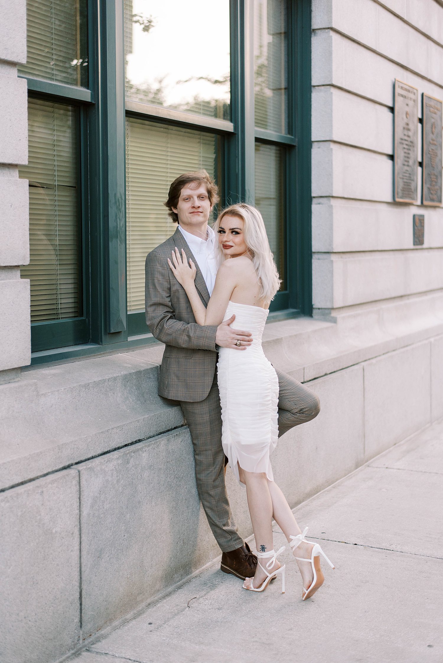 couple leans against hotel wall during downtown Tampa engagement session