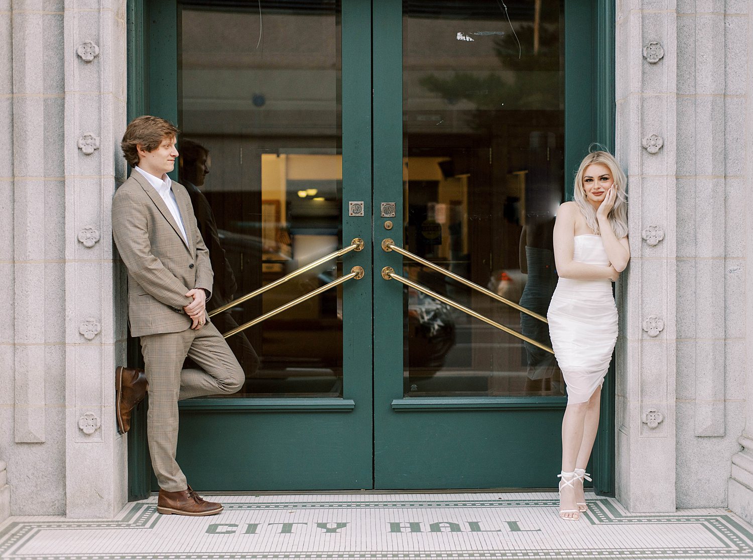engaged couple poses by green doors in Tampa FL