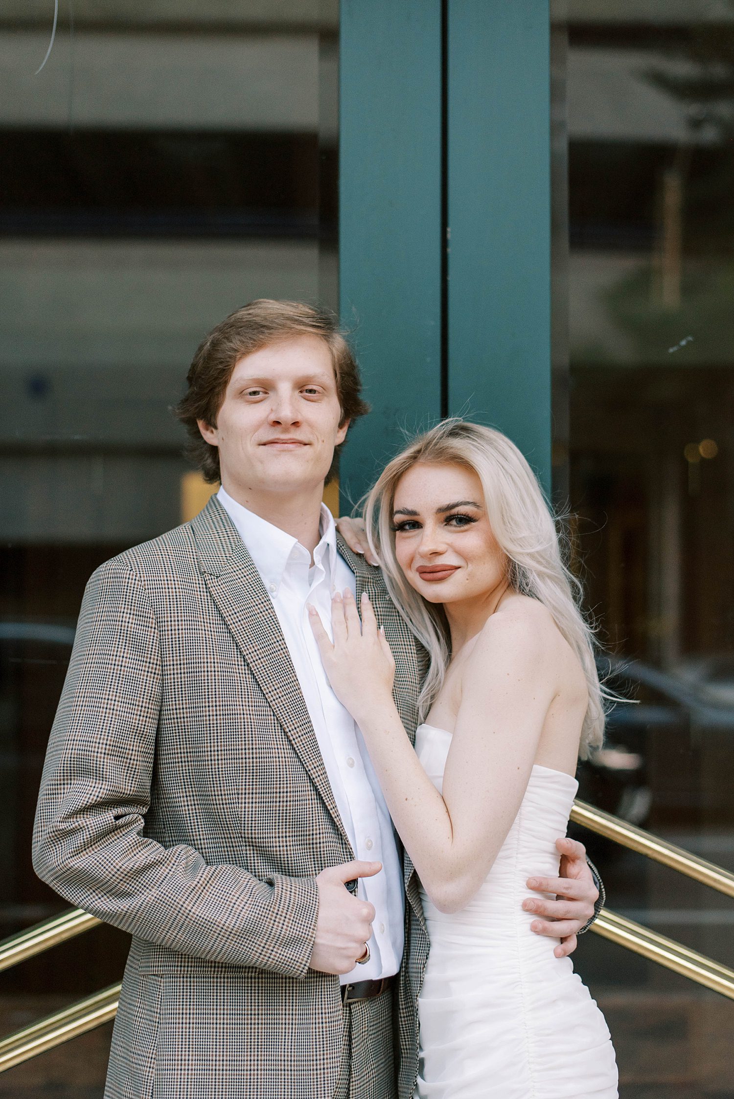 engaged couple stands by green doors of Le Meridien Tampa