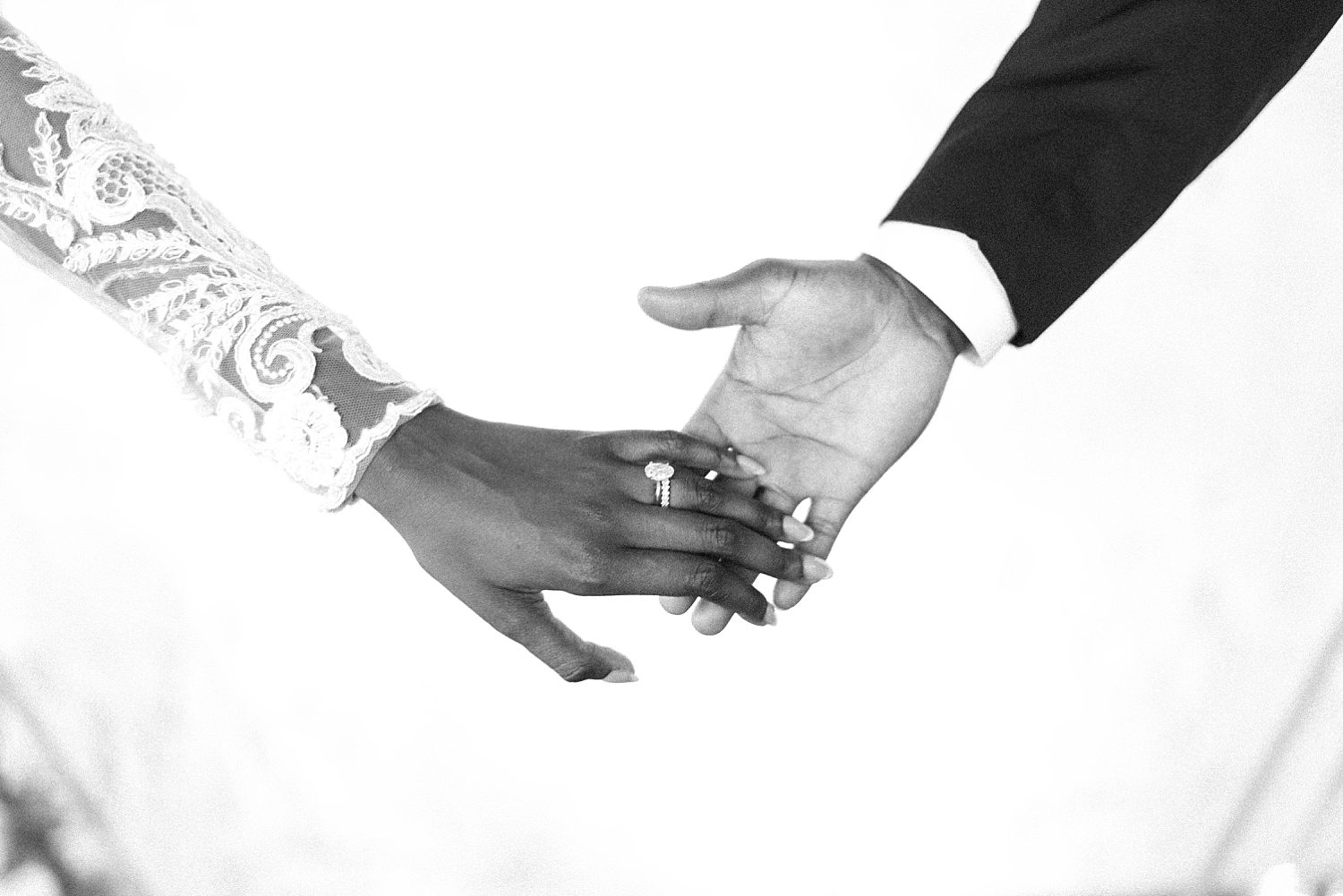 bride and groom hold hands showing off bride's diamond ring
