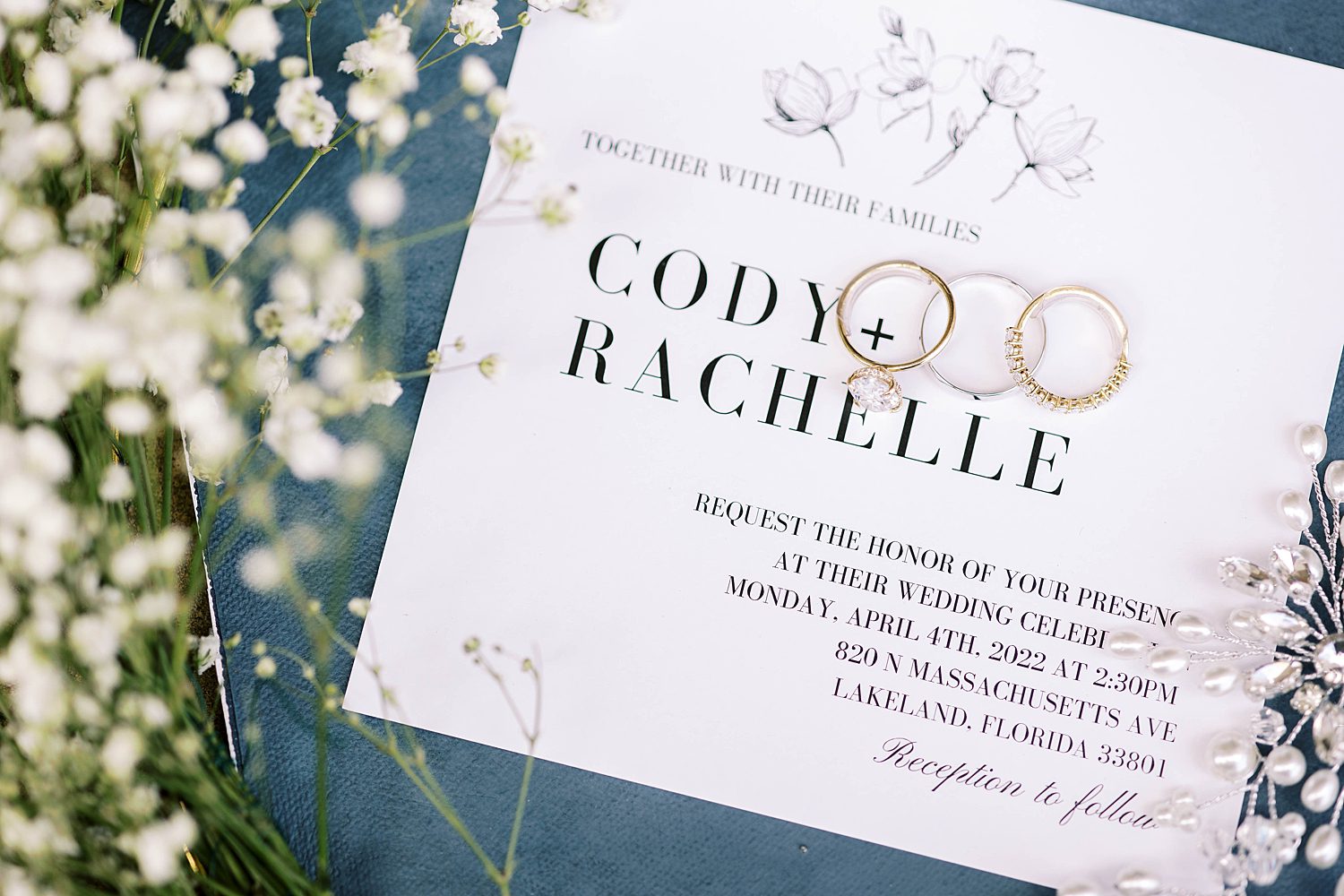gold wedding bands rest on invitation suite for Haus 820 wedding