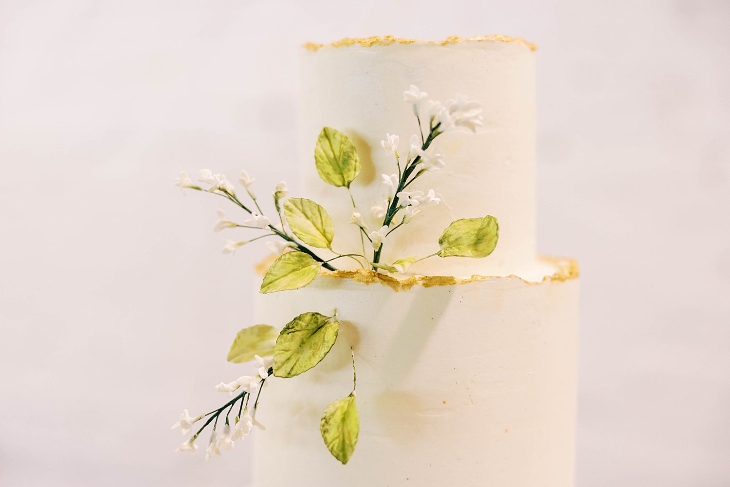 wedding cake with leaves and white flowers for ethereal wedding day