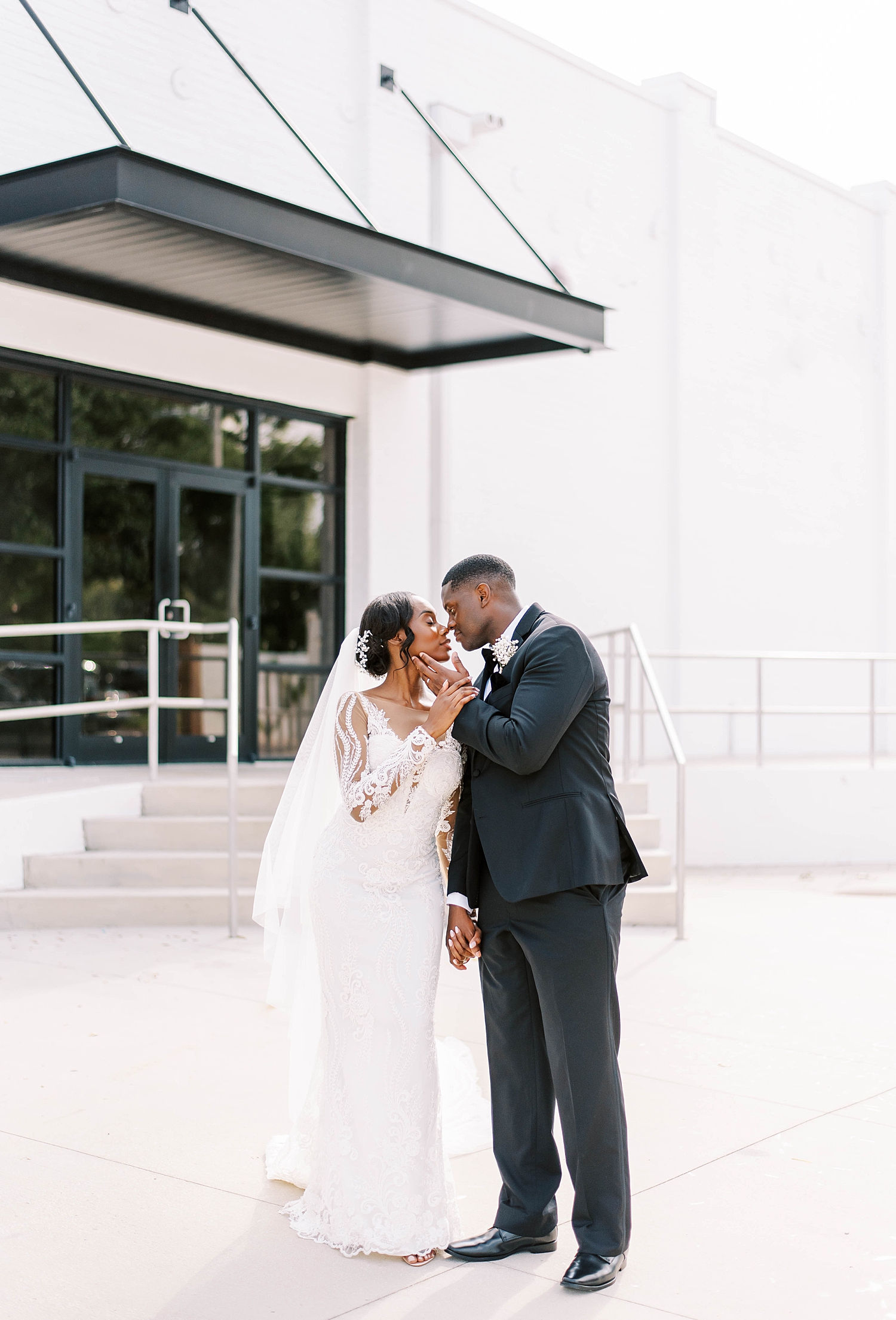 groom holds bride's cheek leaning in to kiss her during FL wedding photos