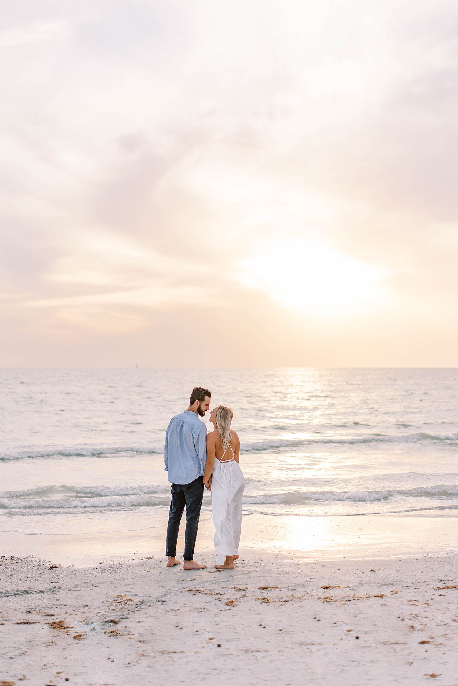 couple leans together along ocean during St. Pete engagement session