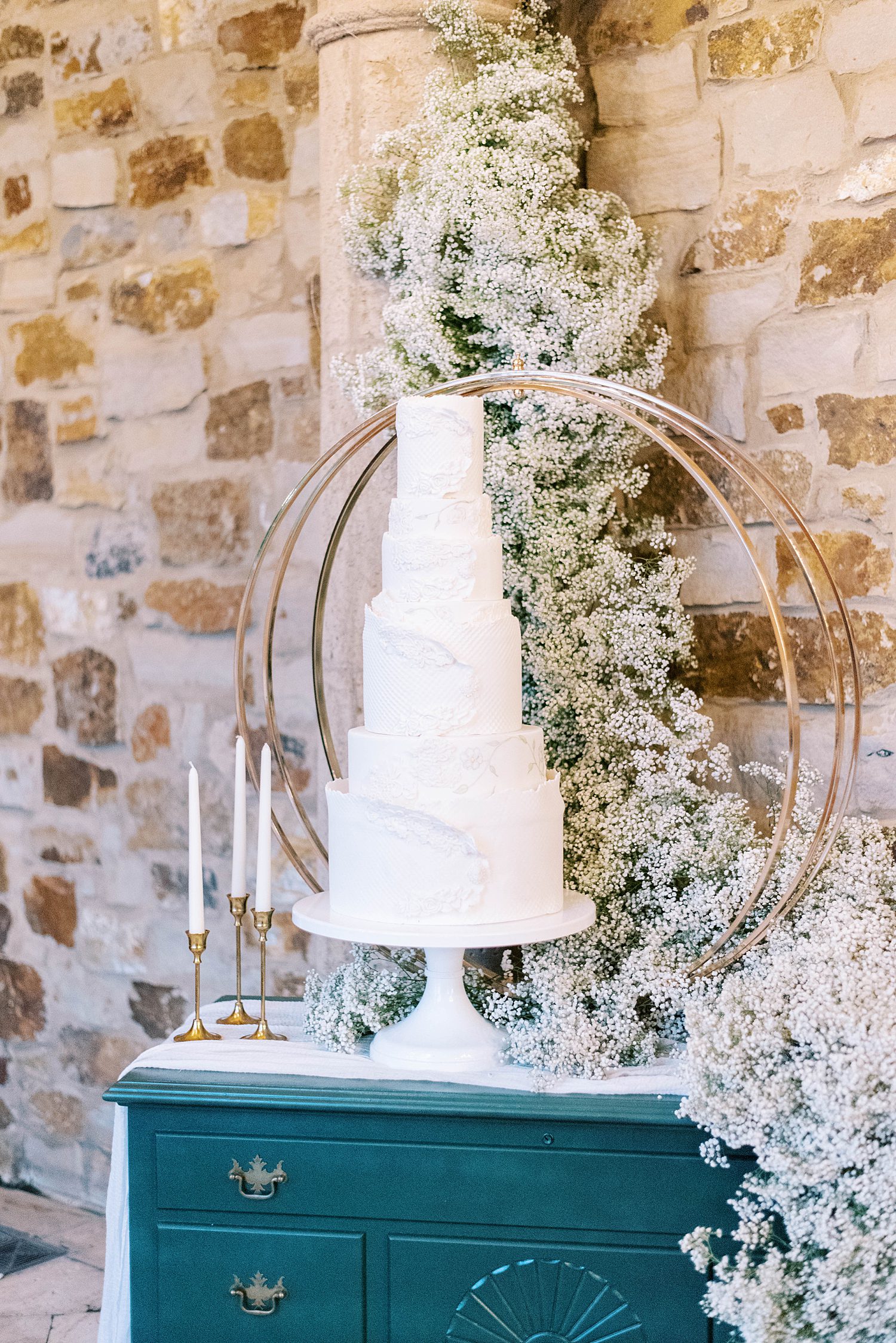 tall white wedding cake with tiers sits on emerald chest