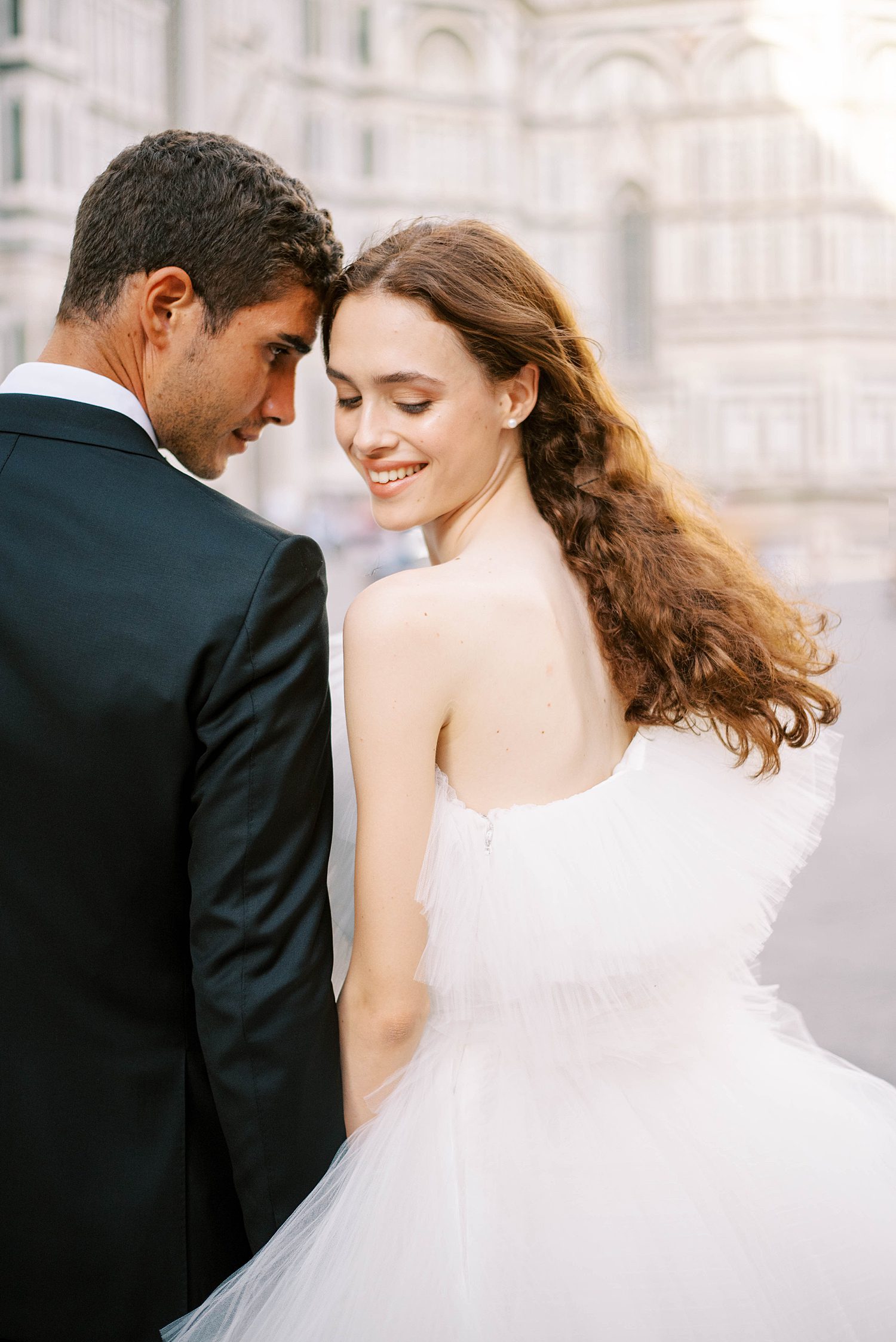 newlyweds hold hands laughing together during Florence wedding day