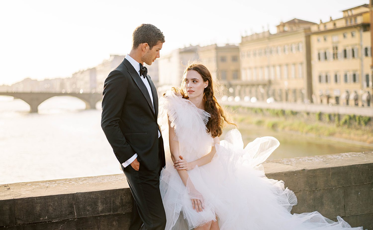 bride looks at groom in classic tux in Florence Italy 