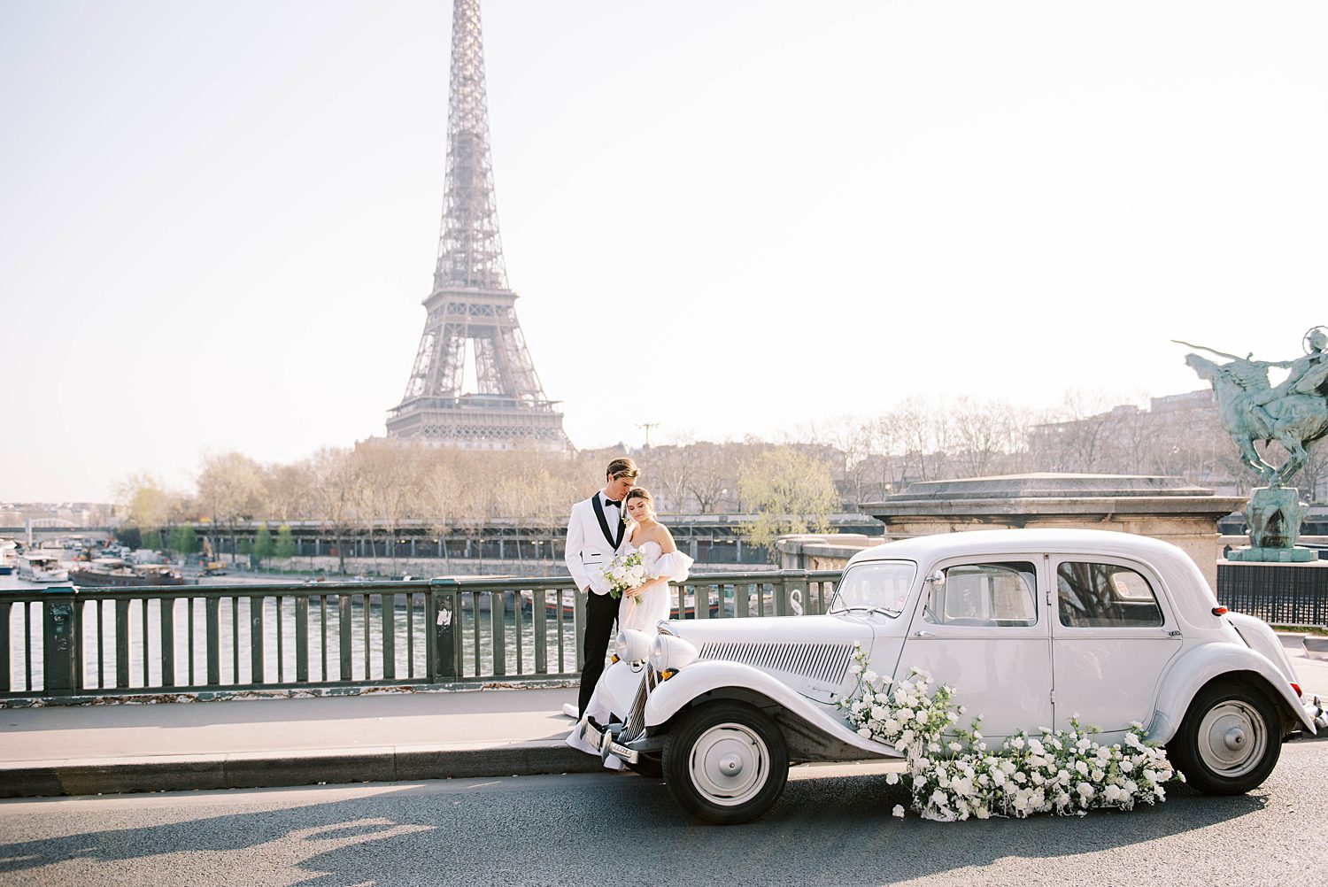 bride and groom pose by antique car by Eiffel Tower