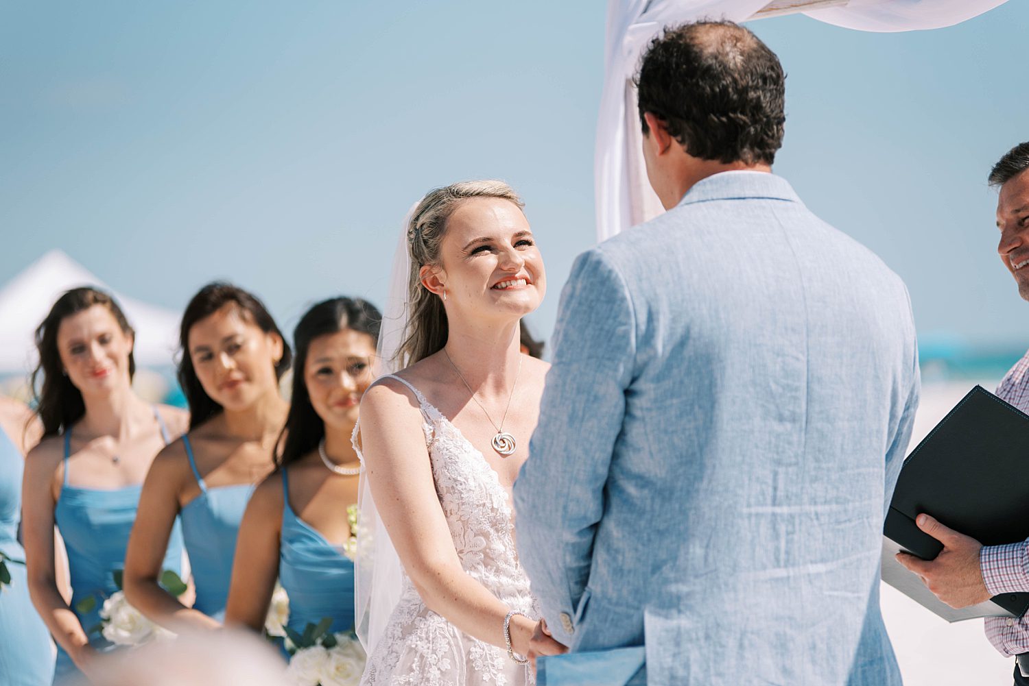 bride smiles up at groom during Siesta Key Beach wedding ceremony