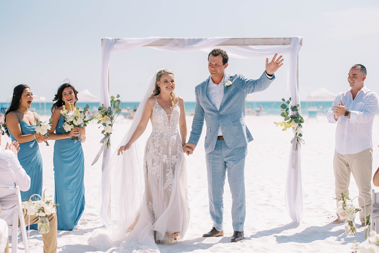 bride and groom wave during wedding ceremony on Siesta Key Beach