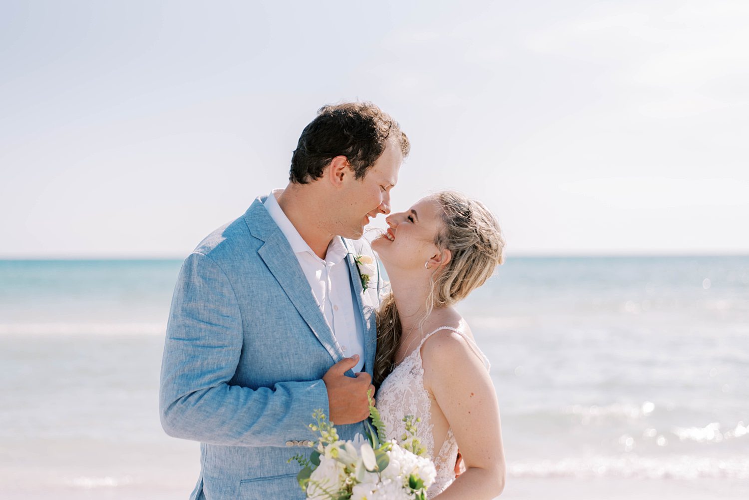bride and groom smile together hugging on Siesta Key Beach