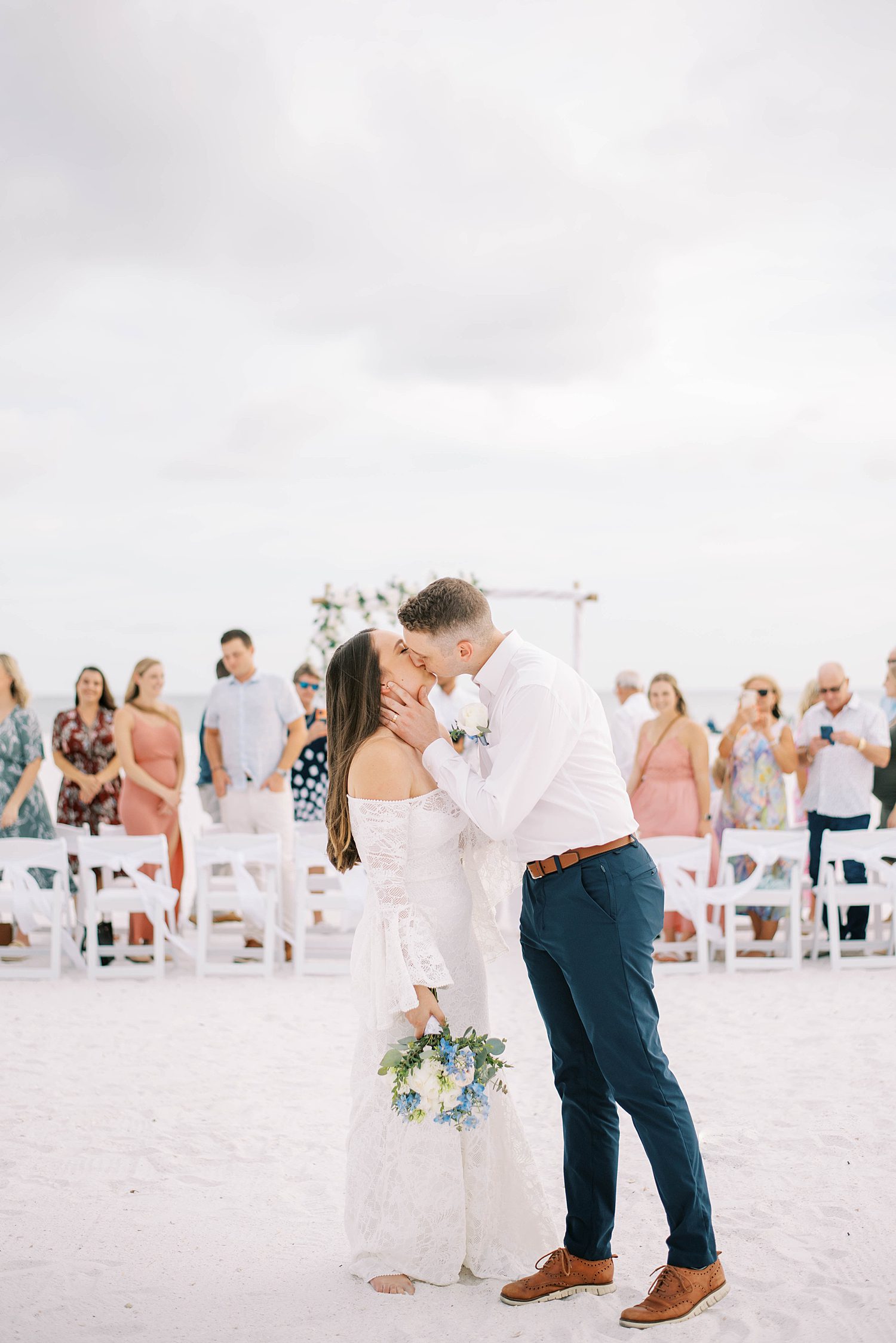 bride and groom kiss at end of aisle at Lido Key Beach