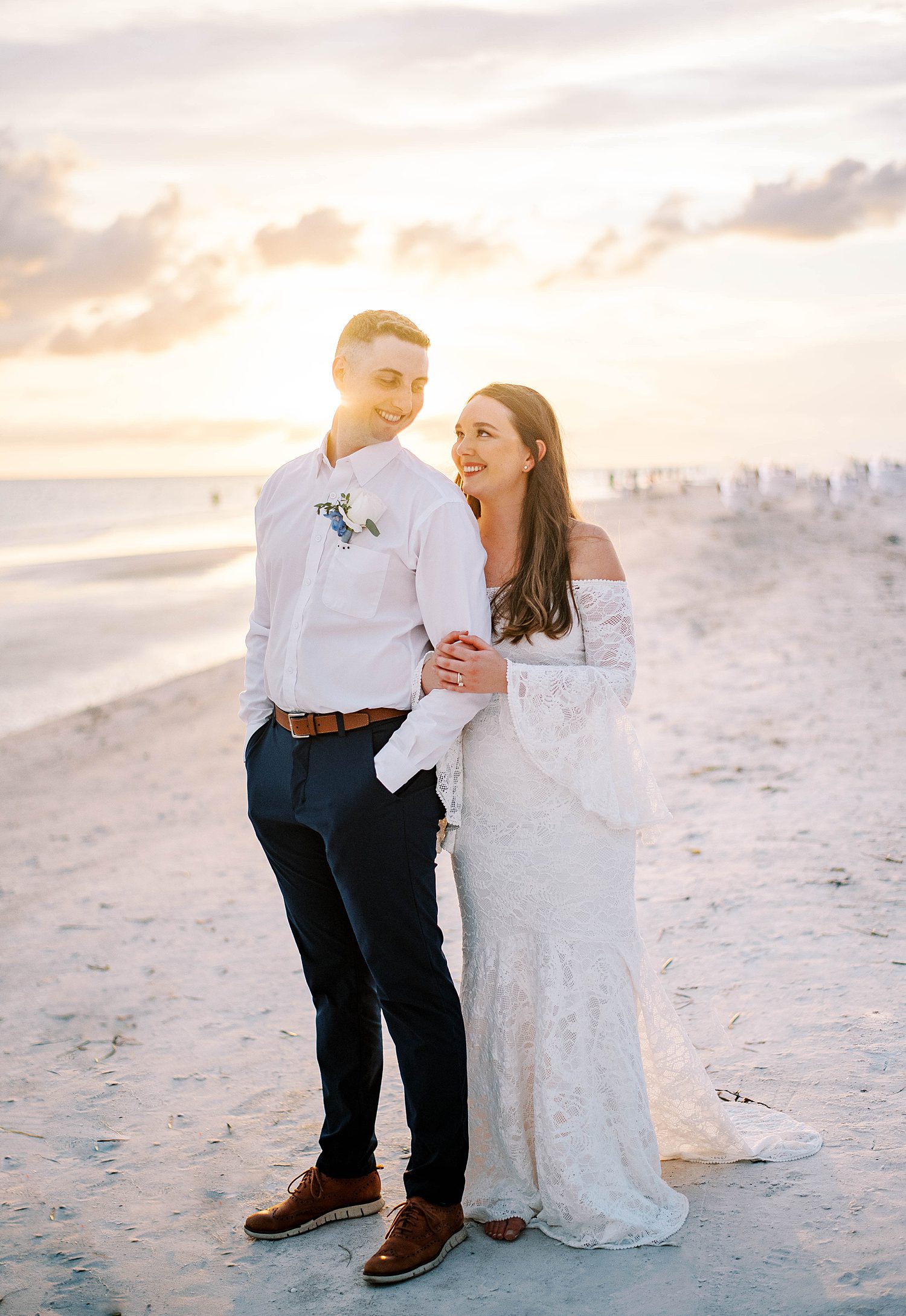 bride and groom hug on beach in Florida