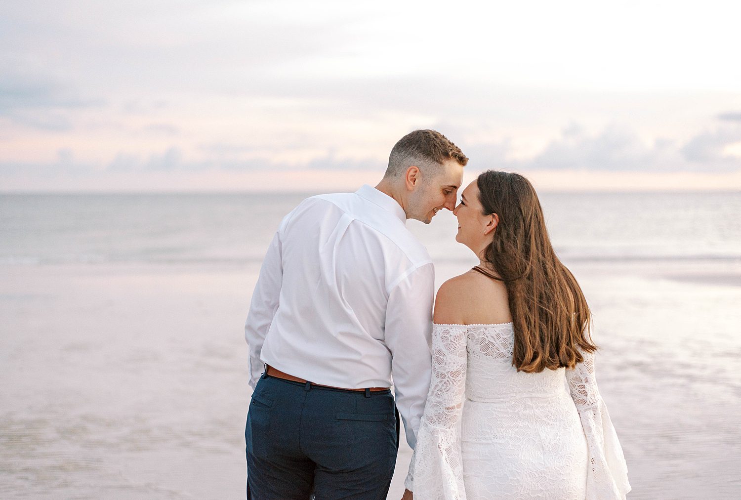 bride and groom lean together touching noses on Lido Key Beach