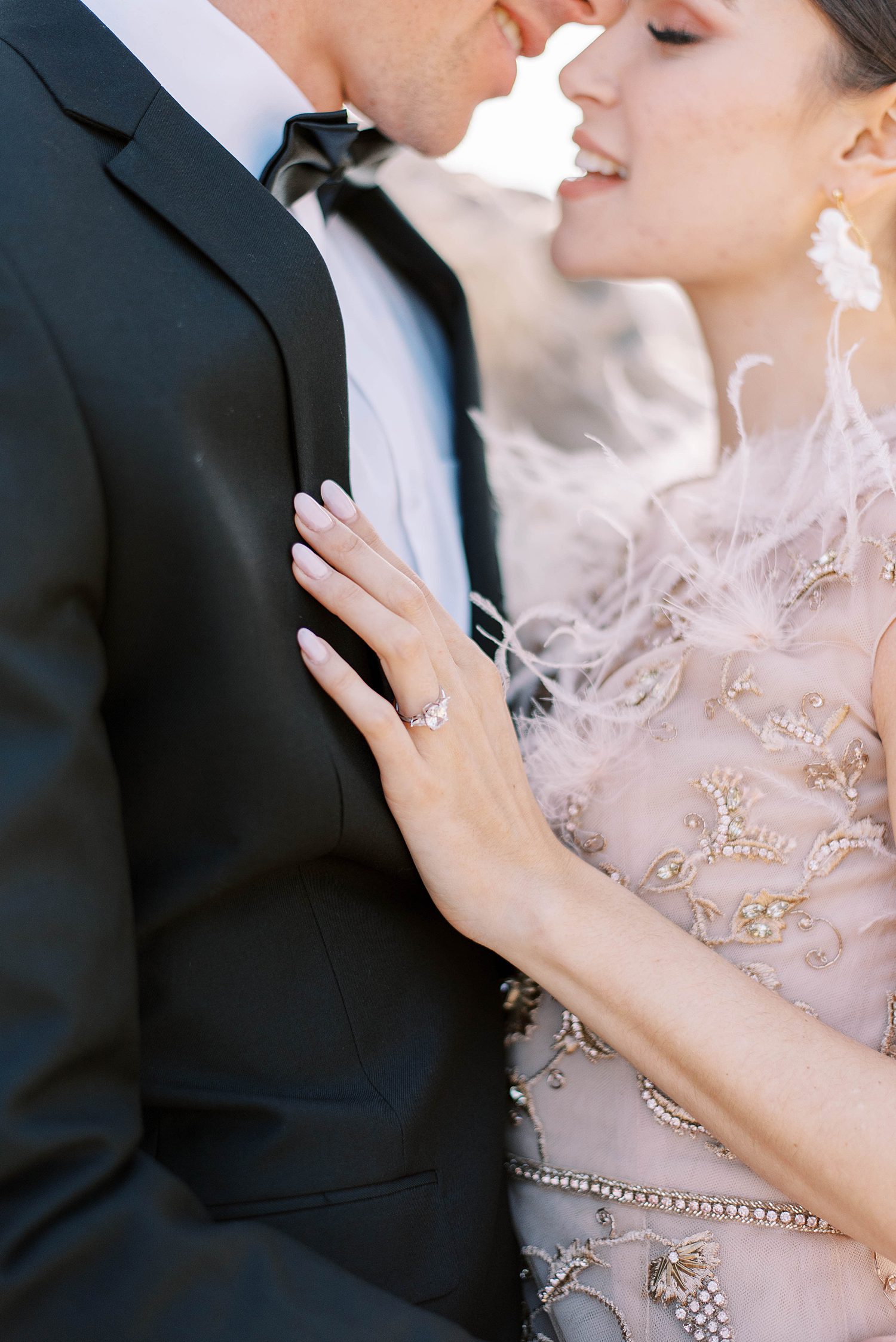 bride holds onto groom's black tux lapel