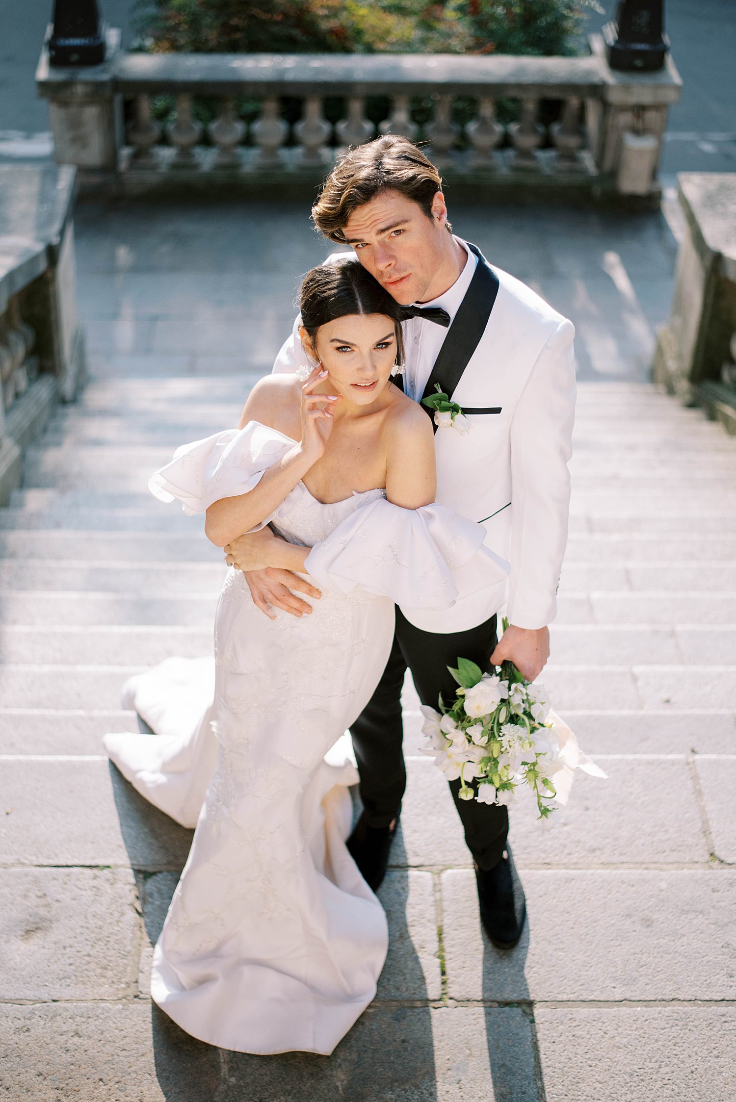 groom hugs bride to his side on side street in Paris